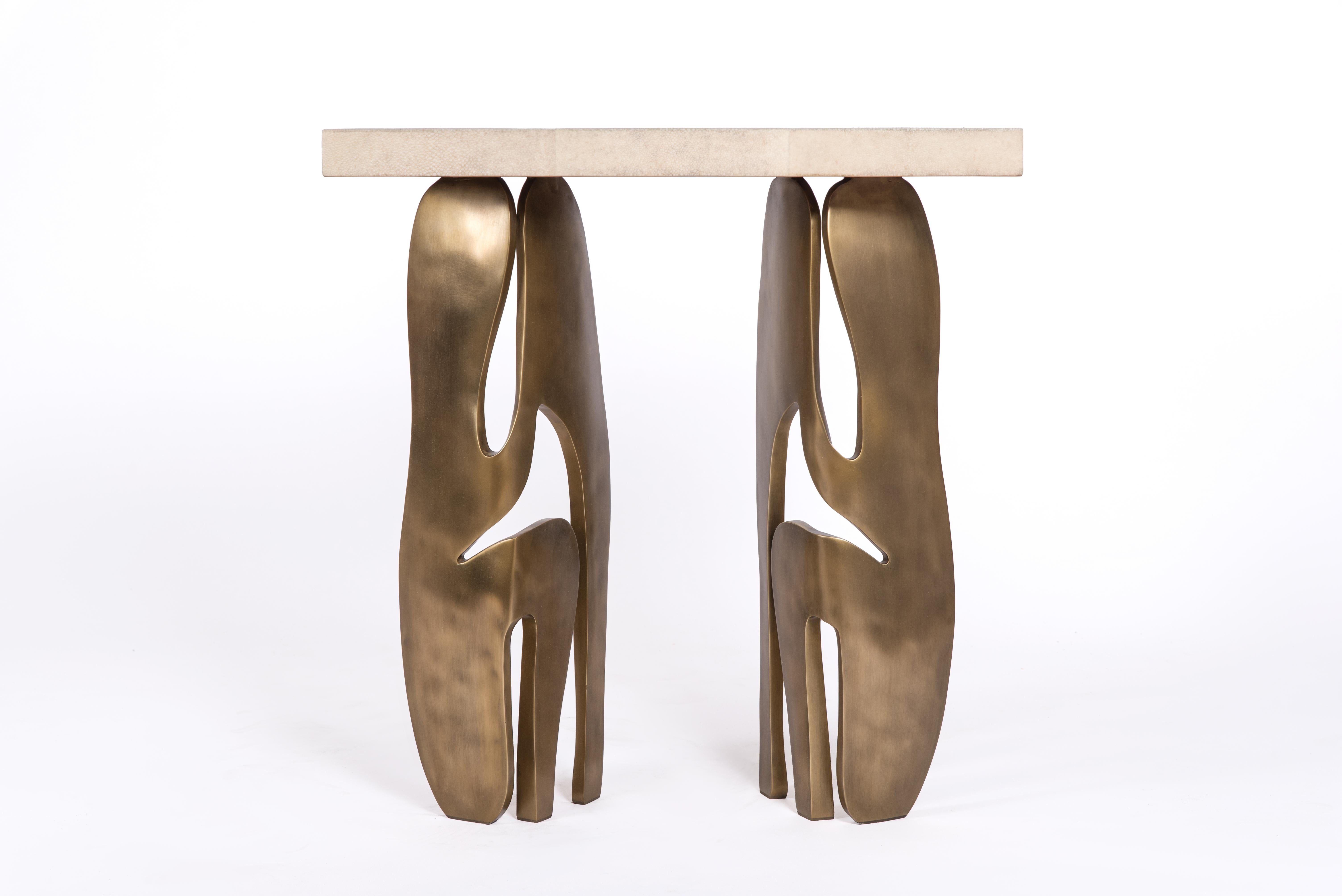 La table d'appoint rectangle Metropolis de R&Y Augousti est à la fois spectaculaire et organique grâce à son design unique. Le plateau en marqueterie de galuchat crème repose sur une paire de pieds éthérés et sculpturaux en laiton bronze-patine.