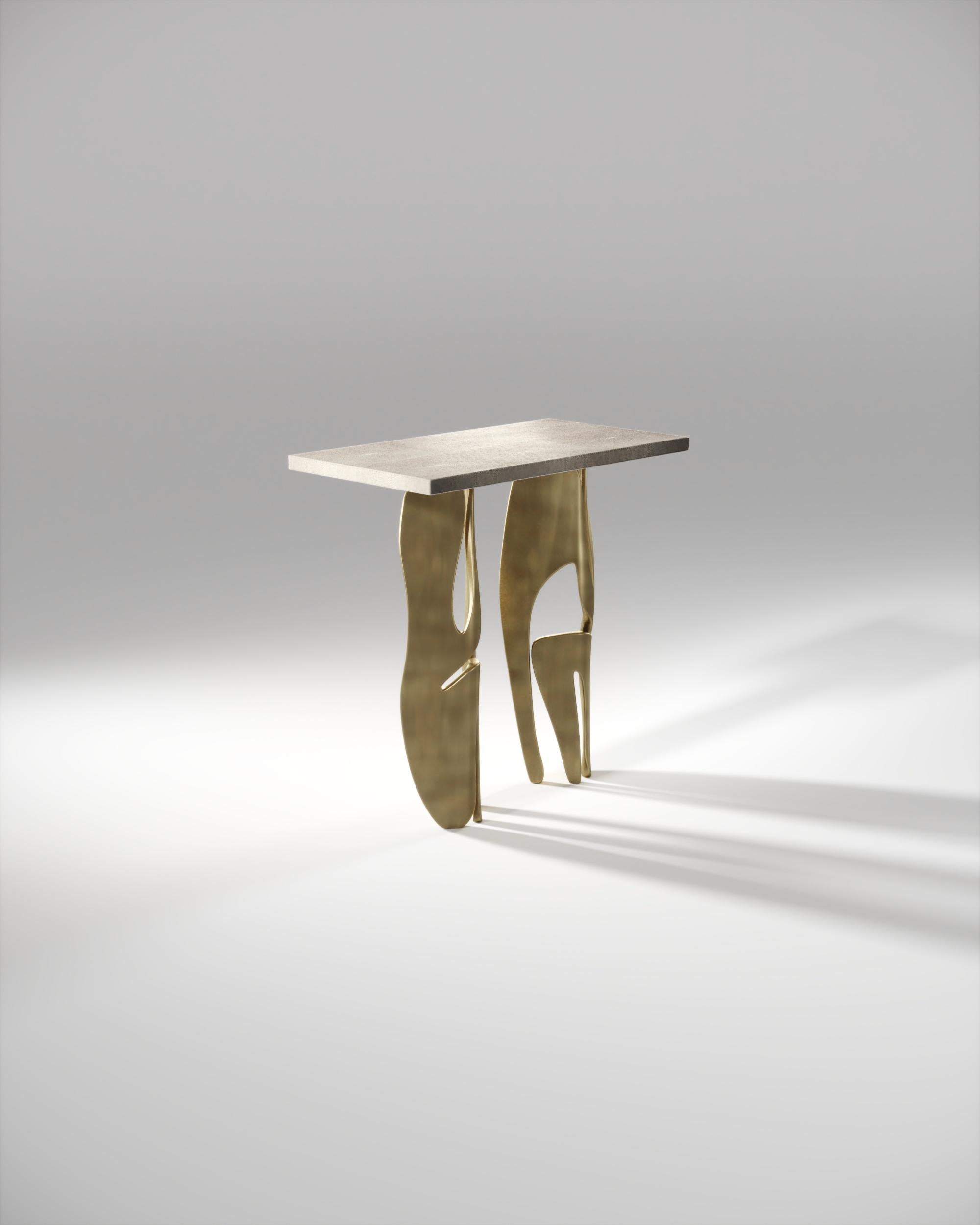 The metropolis rectangle side table by R&Y Augousti is both dramatic and organic it’s unique design. The cream shagreen inlaid top sits on a pair of ethereal and sculptural bronze-patina brass legs. This piece makes for the perfect end table and is