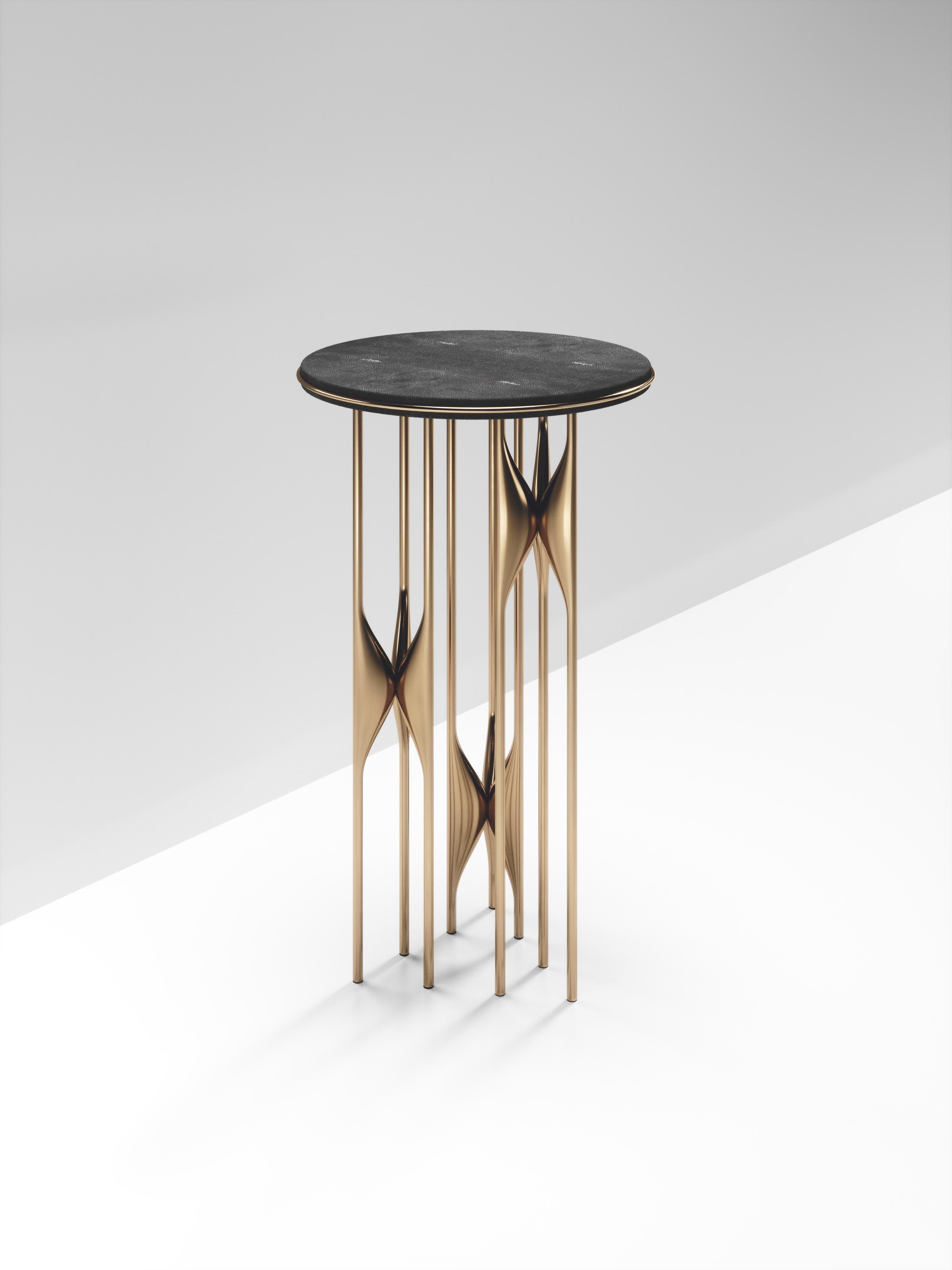The Plumeria Side Table by Kifu Paris is dramatic and sculptural piece. The coal black shagreen inlaid top sits on clusters of bronze-patina brass legs that are conceptually inspired by bird feathers floating on top of a lake. The border of the top
