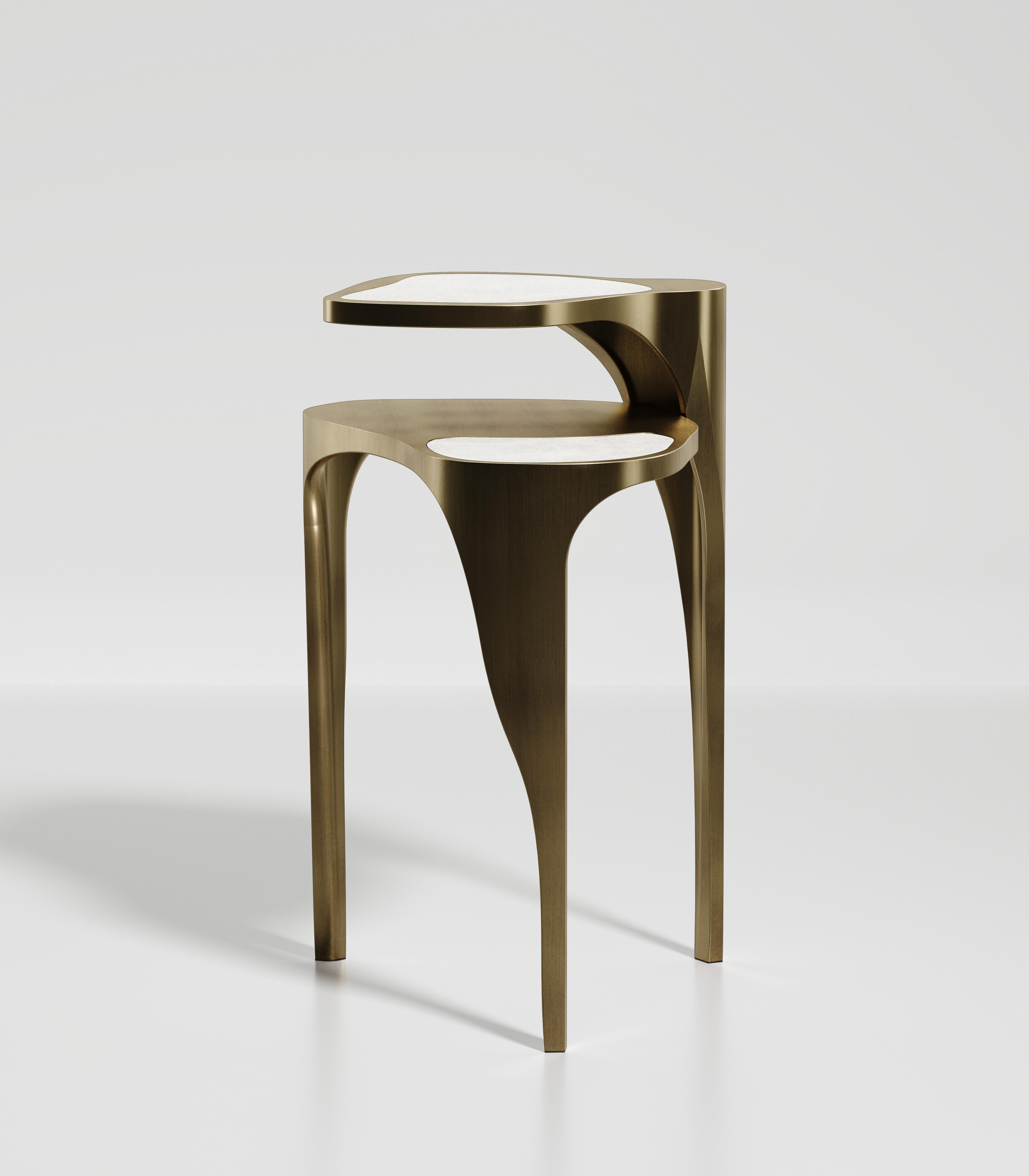La table d'appoint Ginko de R & Y Augousti est une pièce élégante et polyvalente. La pièce est à la fois sculpturale et graphique avec sa forme organique et ses deux parties supérieures flottantes. La pièce est incrustée dans un mélange de galuchat