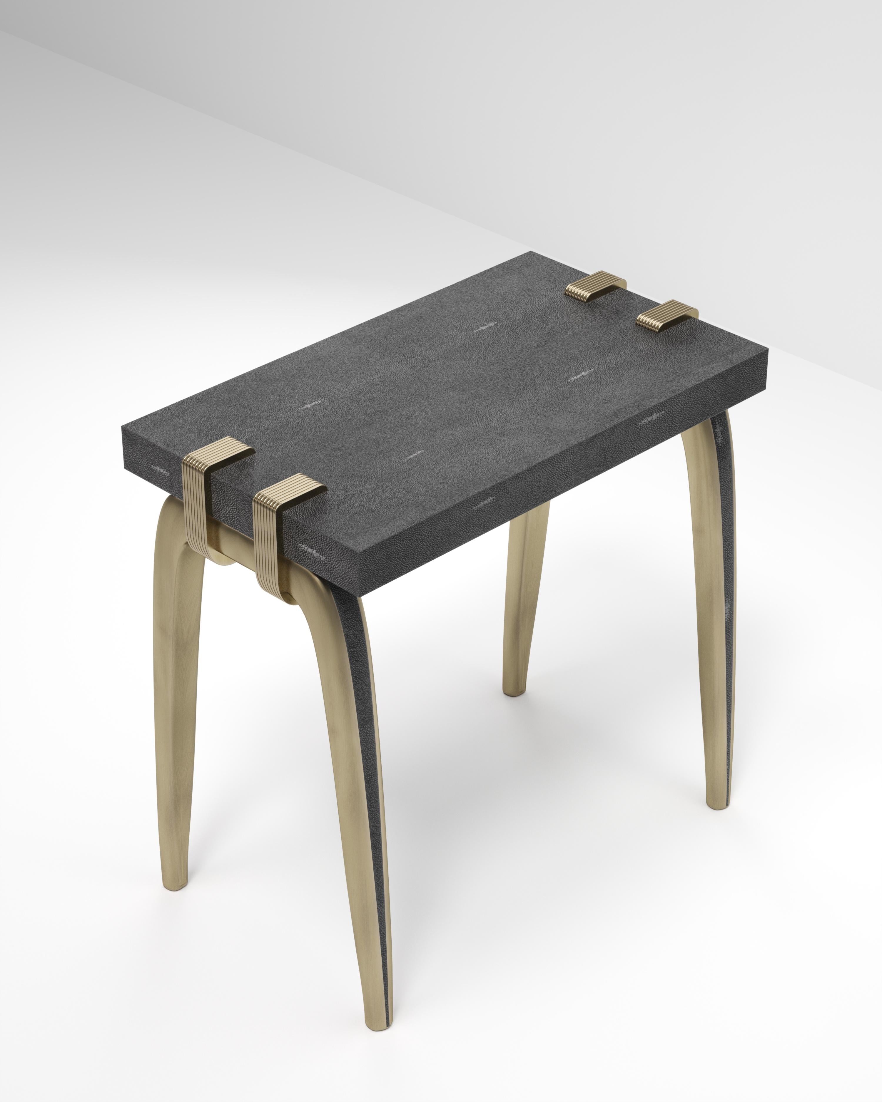 La table d'appoint Sonia est un modèle emblématique d'Augousti, qui met en valeur le savoir-faire exquis de la marque. Les pieds s'accrochent sur le côté du plateau rectangulaire en galuchat noir. Cette pièce est un clin d'œil à la période Art-Déco