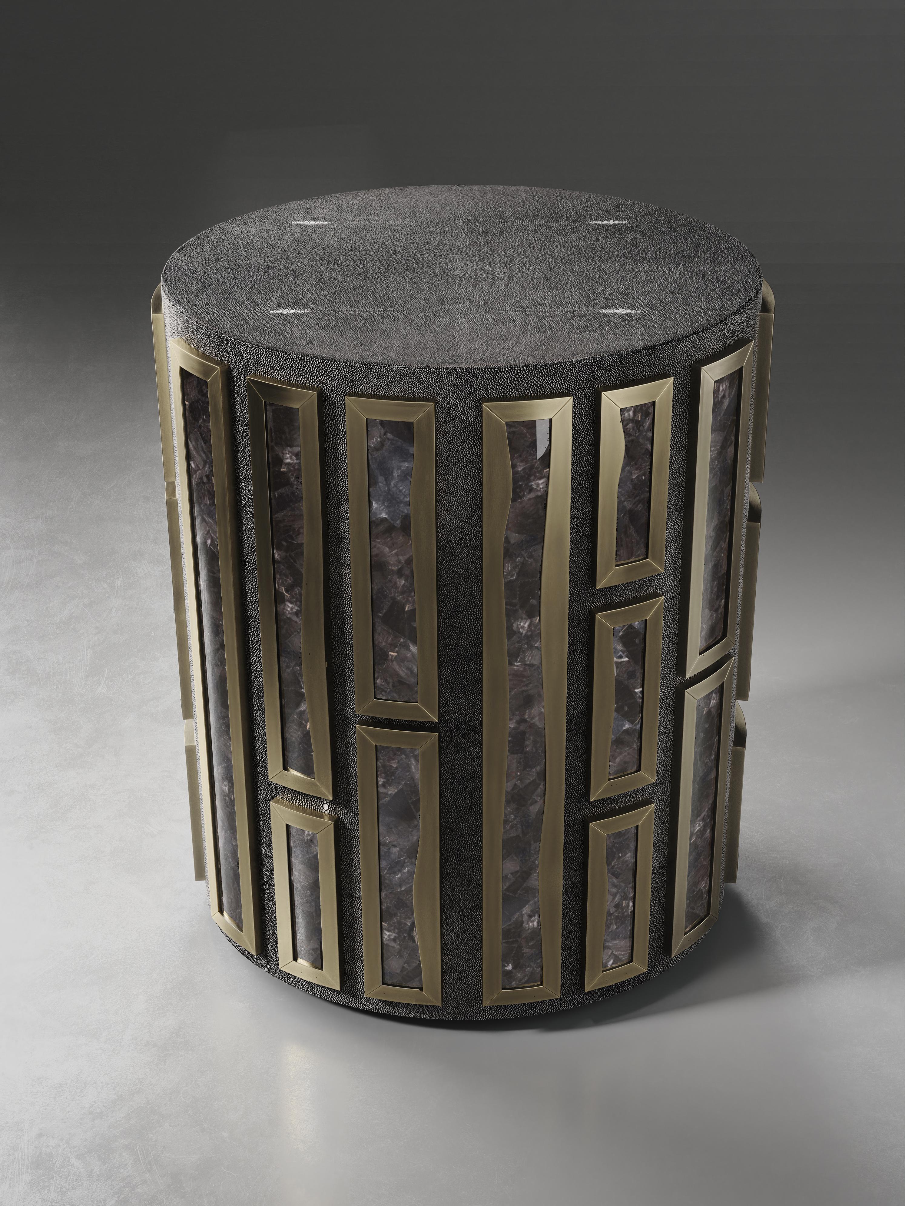 La table d'appoint Talisa de R&Y Augousti s'inspire à l'origine de la version du coffre à bijoux (voir les images à la fin de la diapositive). Cette pièce circulaire est une structure solide incrustée de galuchat noir et ornée d'inserts en quartz