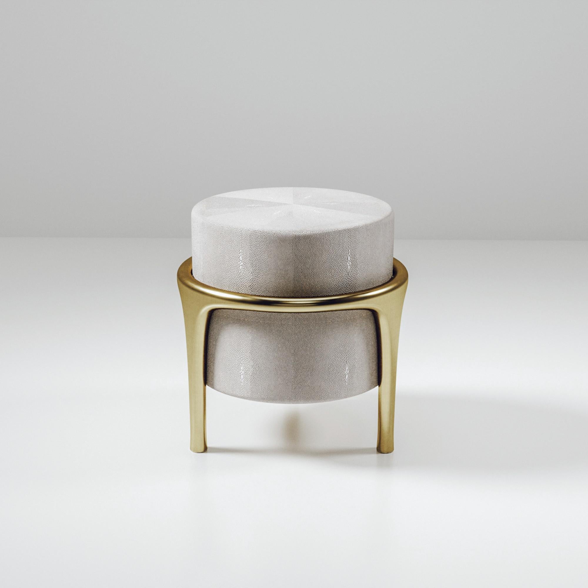 The Ramo Stool by R & Y Augousti is an elegant and versatile piece. The cream shagreen inlaid piece provides comfort while retaining a unique aesthetic with the bronze-patina brass frame and details. This listing is priced for shagreen inlay, see