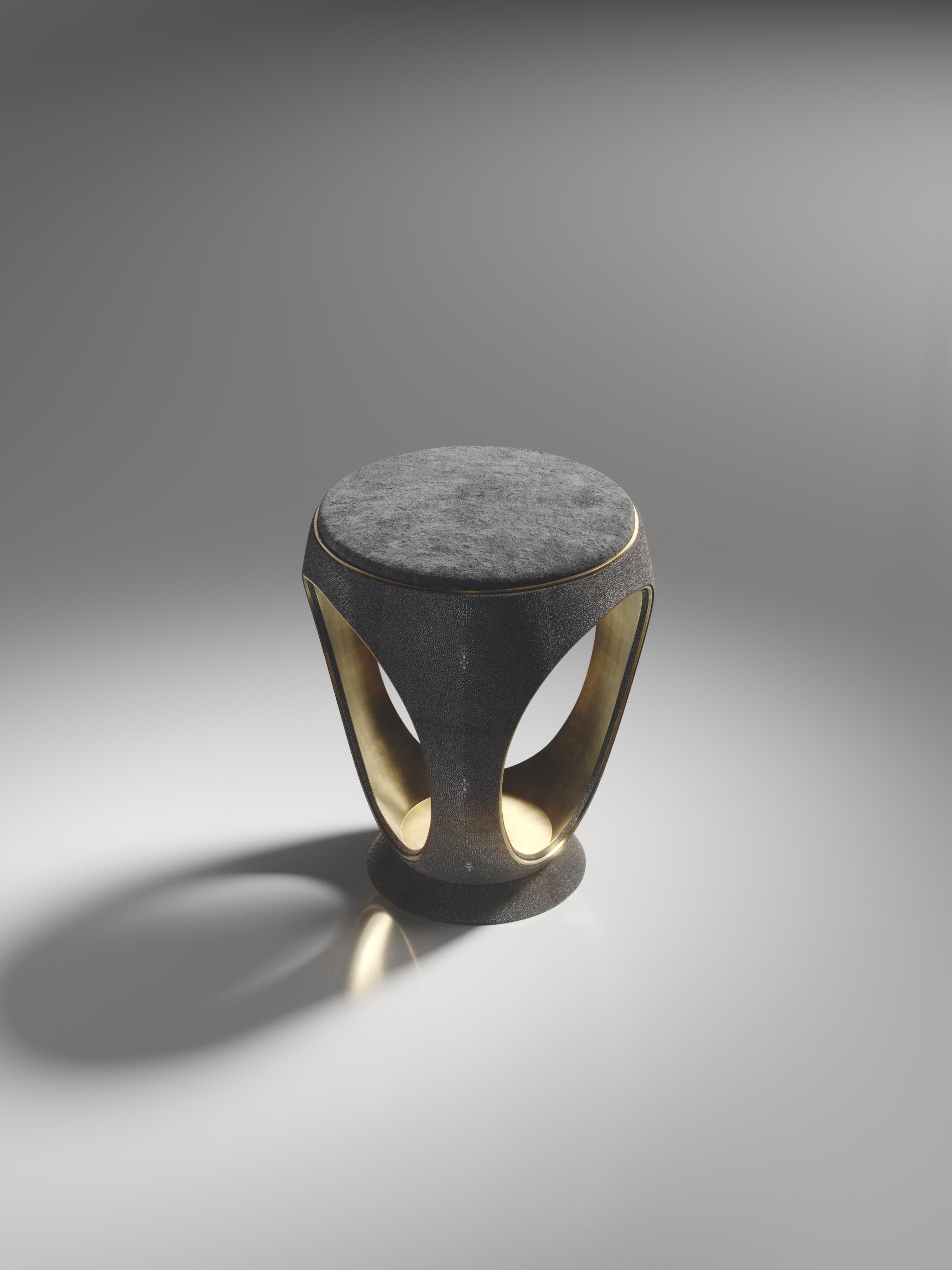 Le tabouret annulaire en galuchat noir est l'une des pièces les plus emblématiques de la Collection R&Y Augousti. De forme sculpturale, semblable à un bijou, cette pièce a été relookée avec un discret détail d'indentation en laiton patiné bronze à