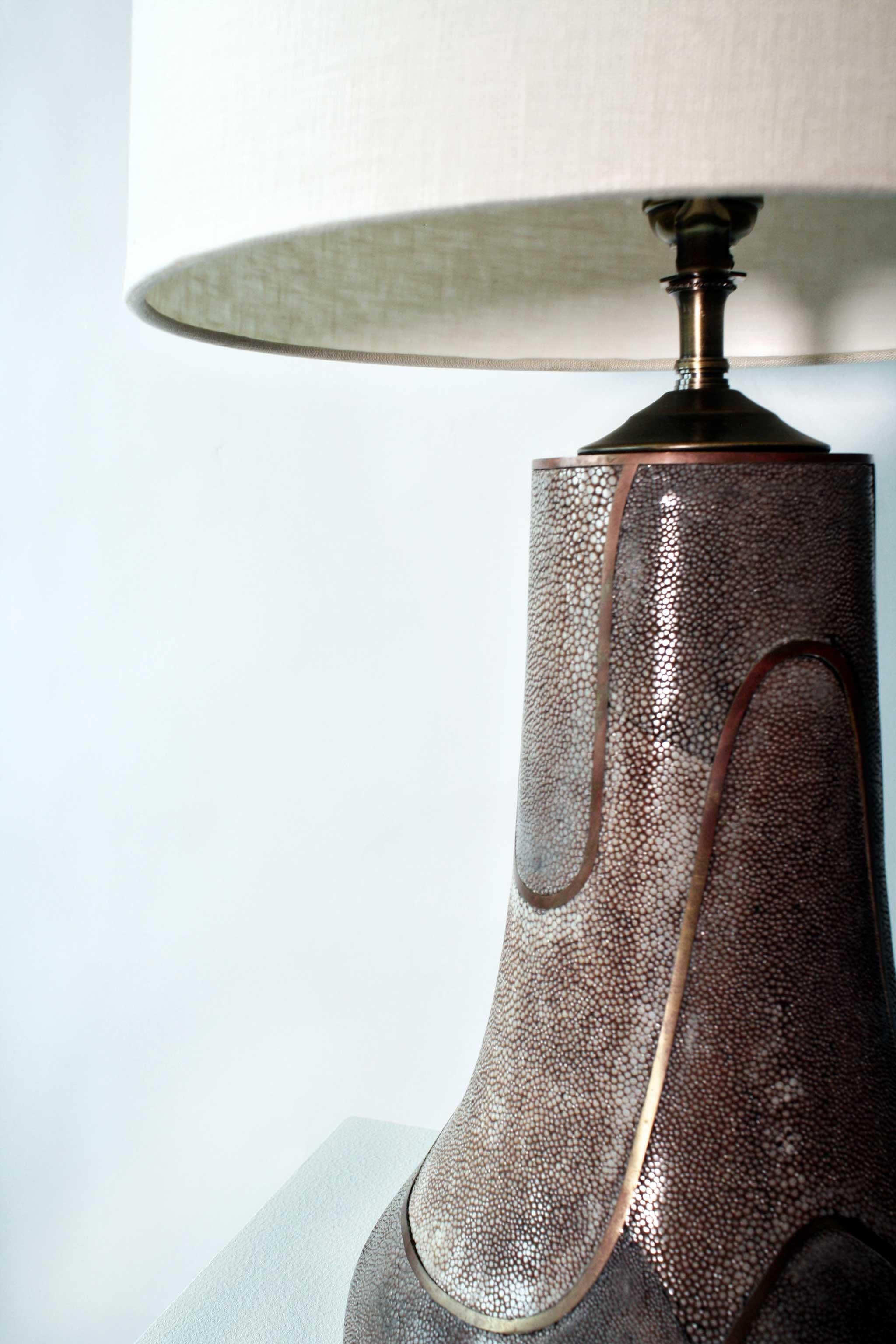 Shagreen Table Lamp, Light Mauve & Bronze, Circa Late 20th Century.

One-of-a-kind stingray shagreen table lamp with intricate bronze curved metal detail. Vintage from the late 20th century, this piece is unique, rare, and traditionally handmade