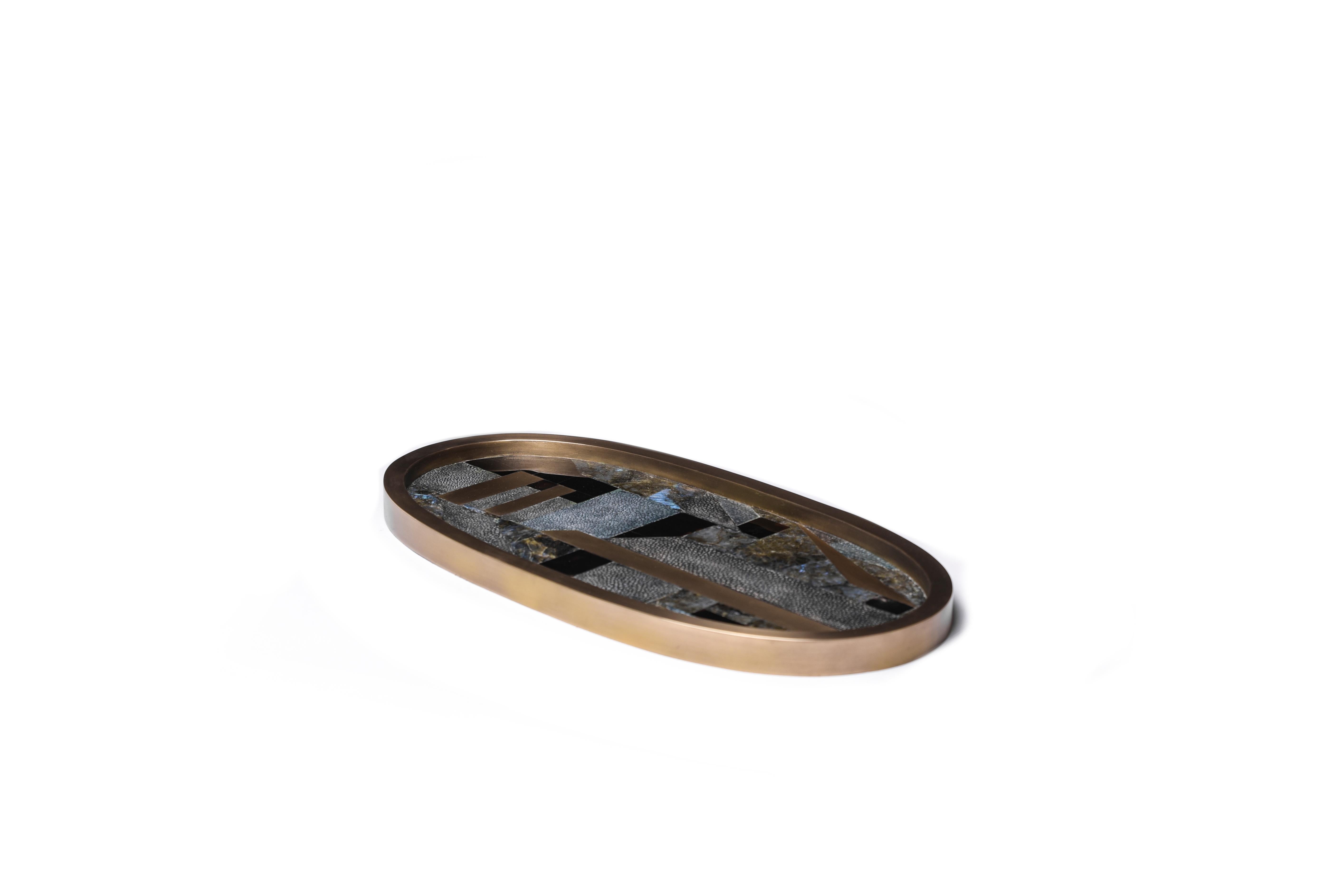 Un plateau ovale classique revisité ; ce plateau géométrique de Kifu Paris est incrusté d'un mélange de galuchat bleu, de coquillage noir, de quartz lémurien et de laiton bronze-patiné, ce qui en fait une pièce de table étonnante dans n'importe quel