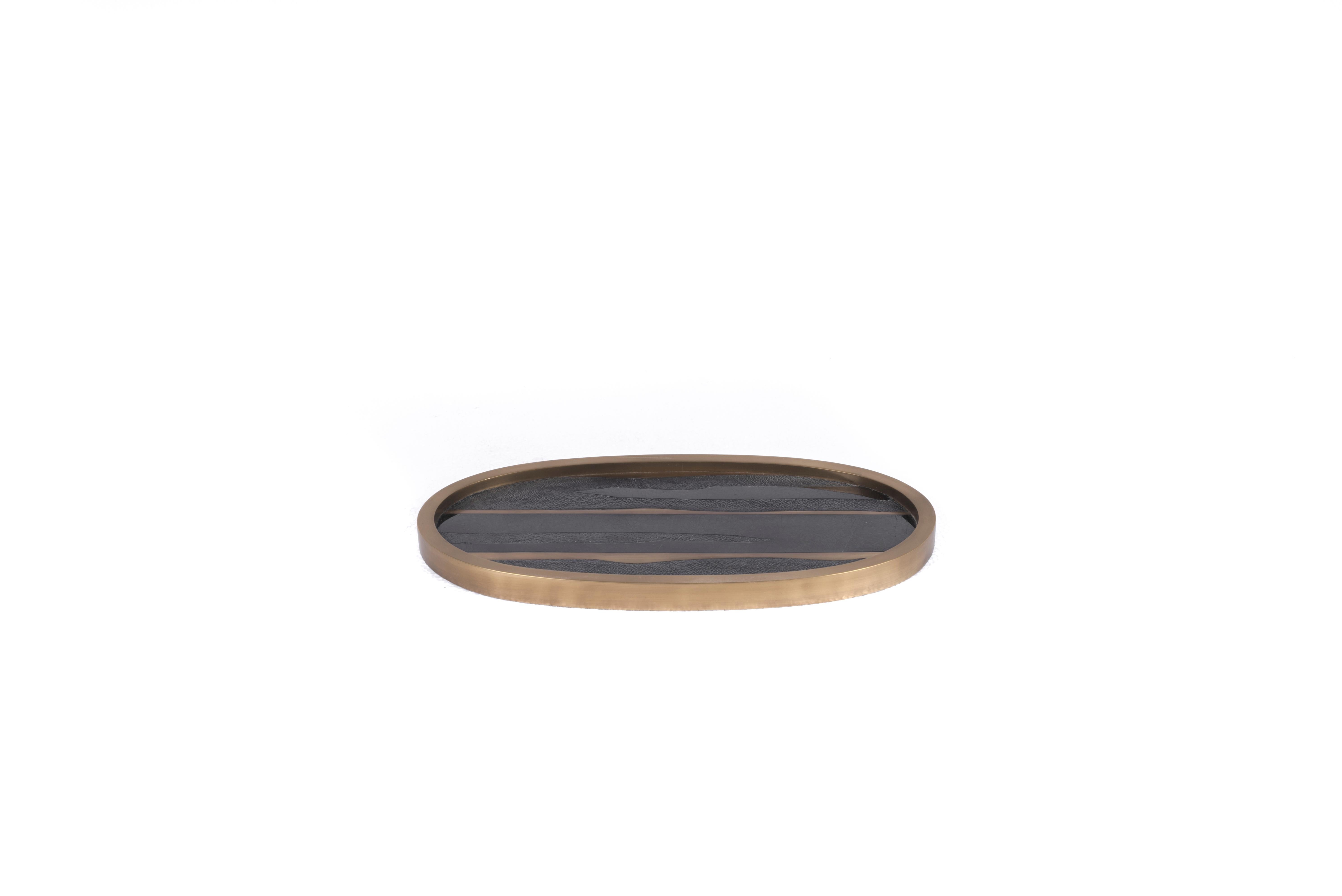 A Classic oval vanity tray revisited; this Kifu Paris nautical-striped pattern tray is inlaid in a mixture of coal black shagreen, black shell, and bronze-patina brass, making for a stunning tabletop piece in any space. The frame is inlaid in