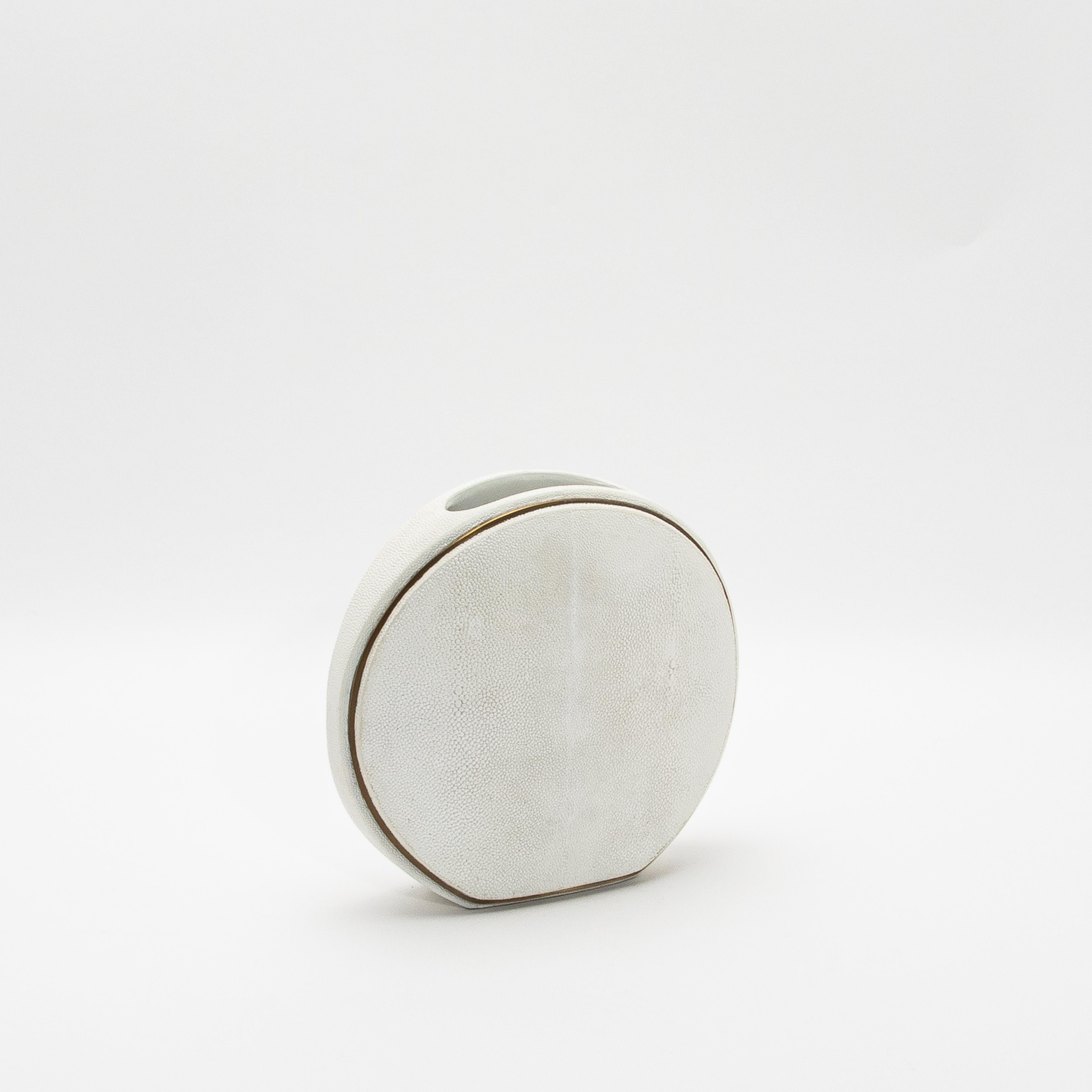 Este exquisito jarrón de R&Y Augousti captura la esencia de la artesanía con su lujosa superficie de piel de zapa, complementada con la elegancia de los detalles de latón acabados a mano. La forma redonda ofrece una silueta escultural y moderna,