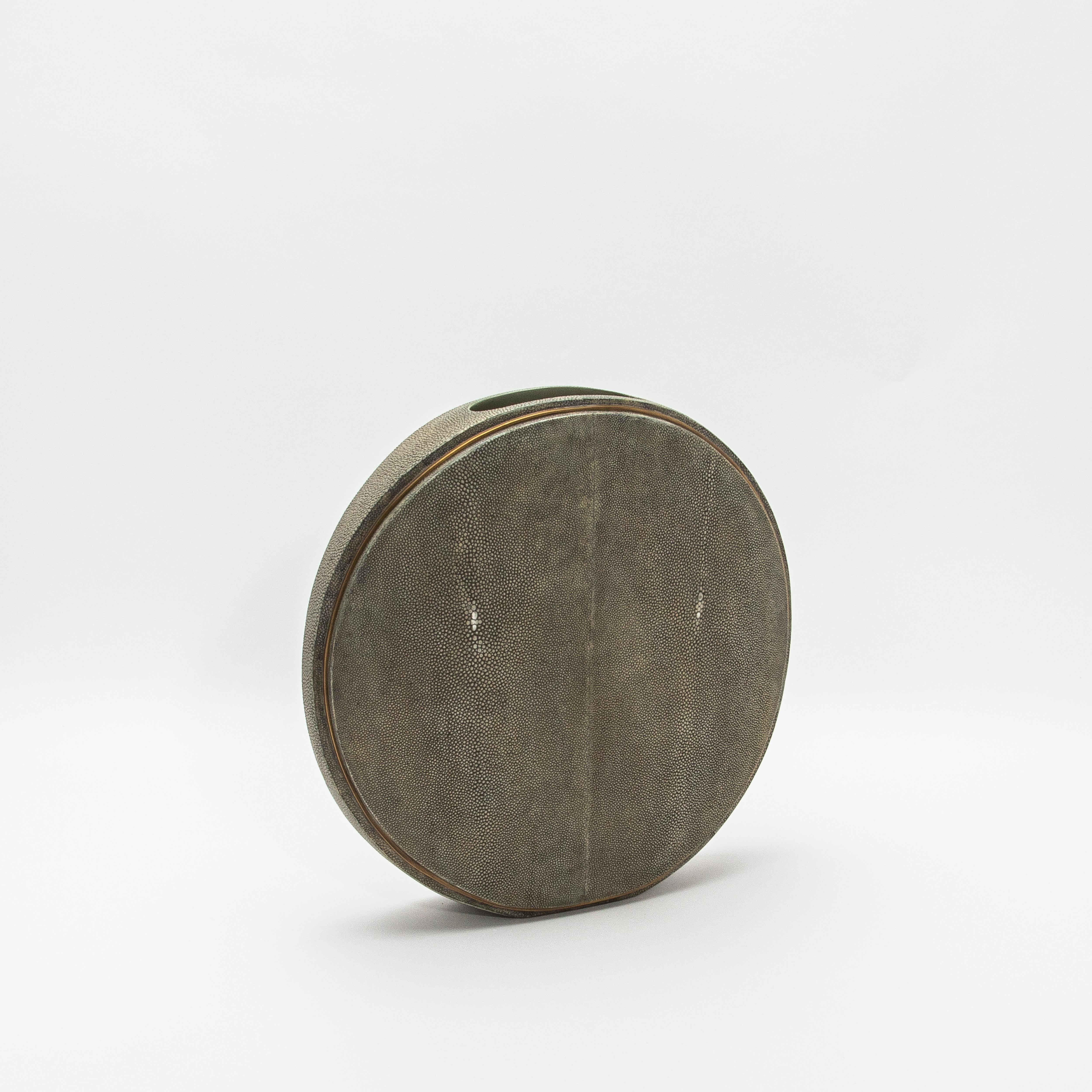 Este exquisito jarrón de R&Y Augousti captura la esencia de la artesanía con su lujosa superficie de piel de zapa, complementada con la elegancia de los detalles de latón acabados a mano. La forma redonda ofrece una silueta escultural y moderna,
