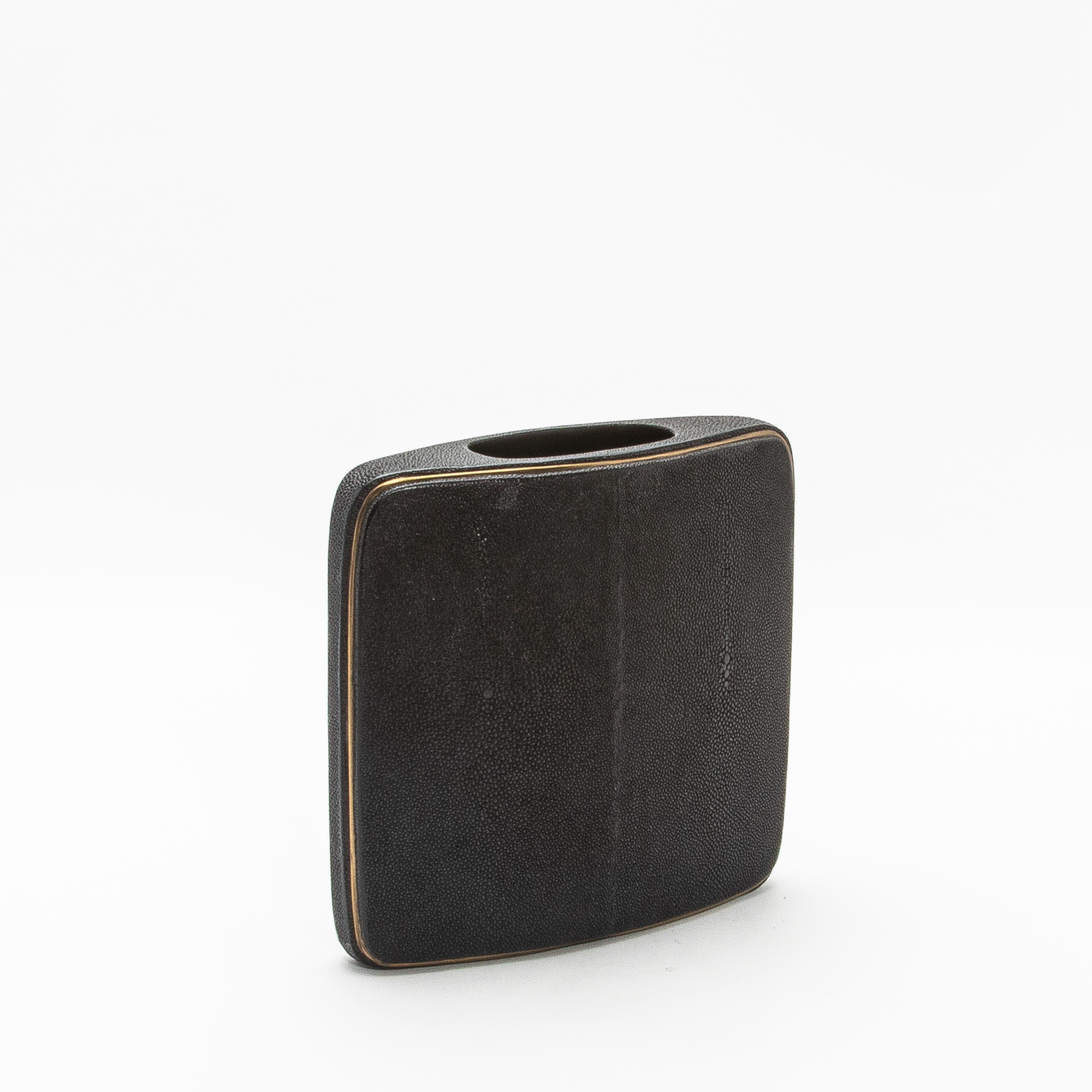 El Jarrón Shagreen de R&Y Augousti es una mezcla perfecta de materiales lujosos y artesanía refinada. Su forma cuadrada y compacta está envuelta en piel de raya, que ofrece una textura sutil pero táctil que habla de elegancia atemporal. El estampado