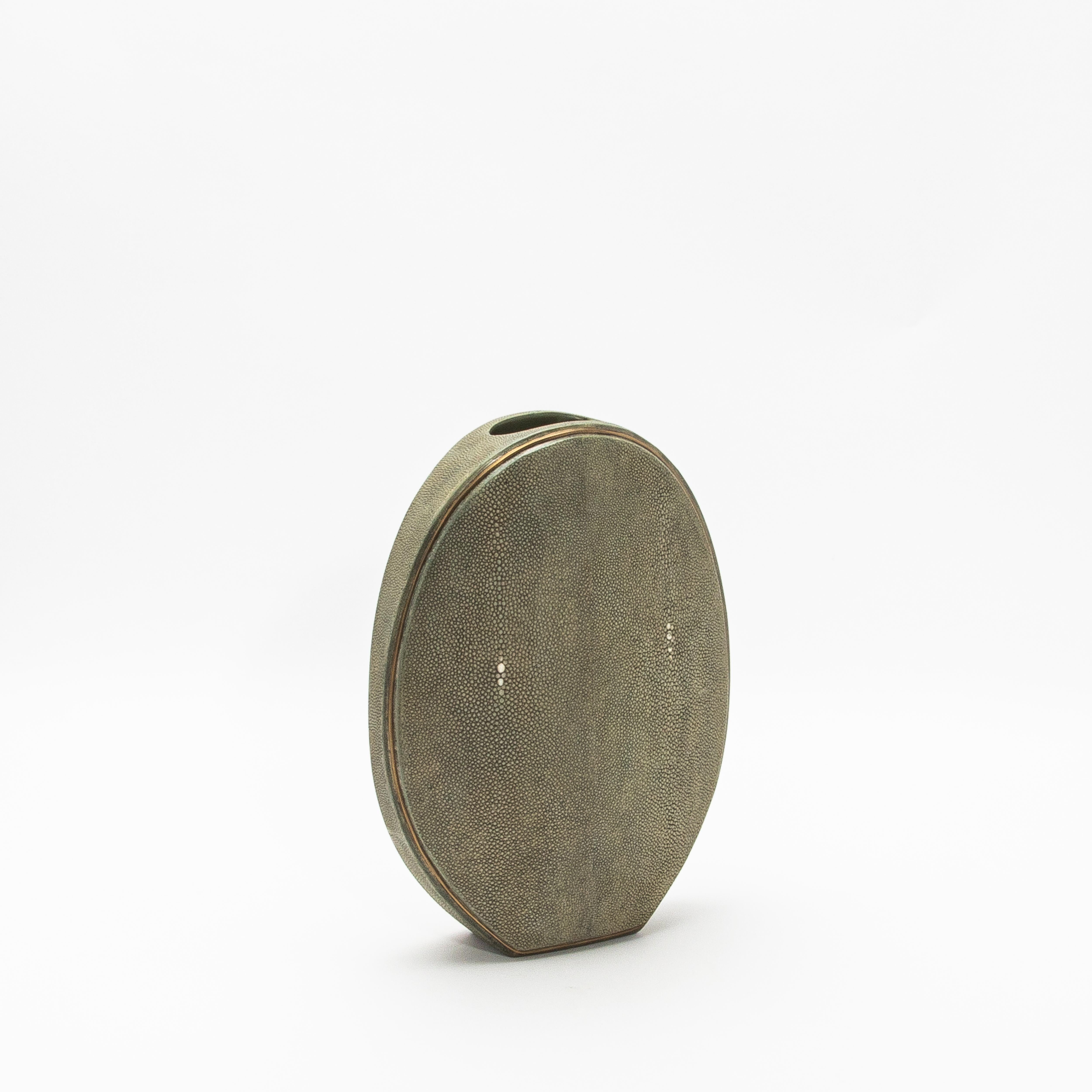 L'élégant vase ovale de R&Y Augousti, réalisé en galuchat et rehaussé de laiton, est une fusion sophistiquée de textures organiques et de détails luxueux. Sa silhouette ovale présente une forme saisissante, rehaussée par le placement méticuleux du