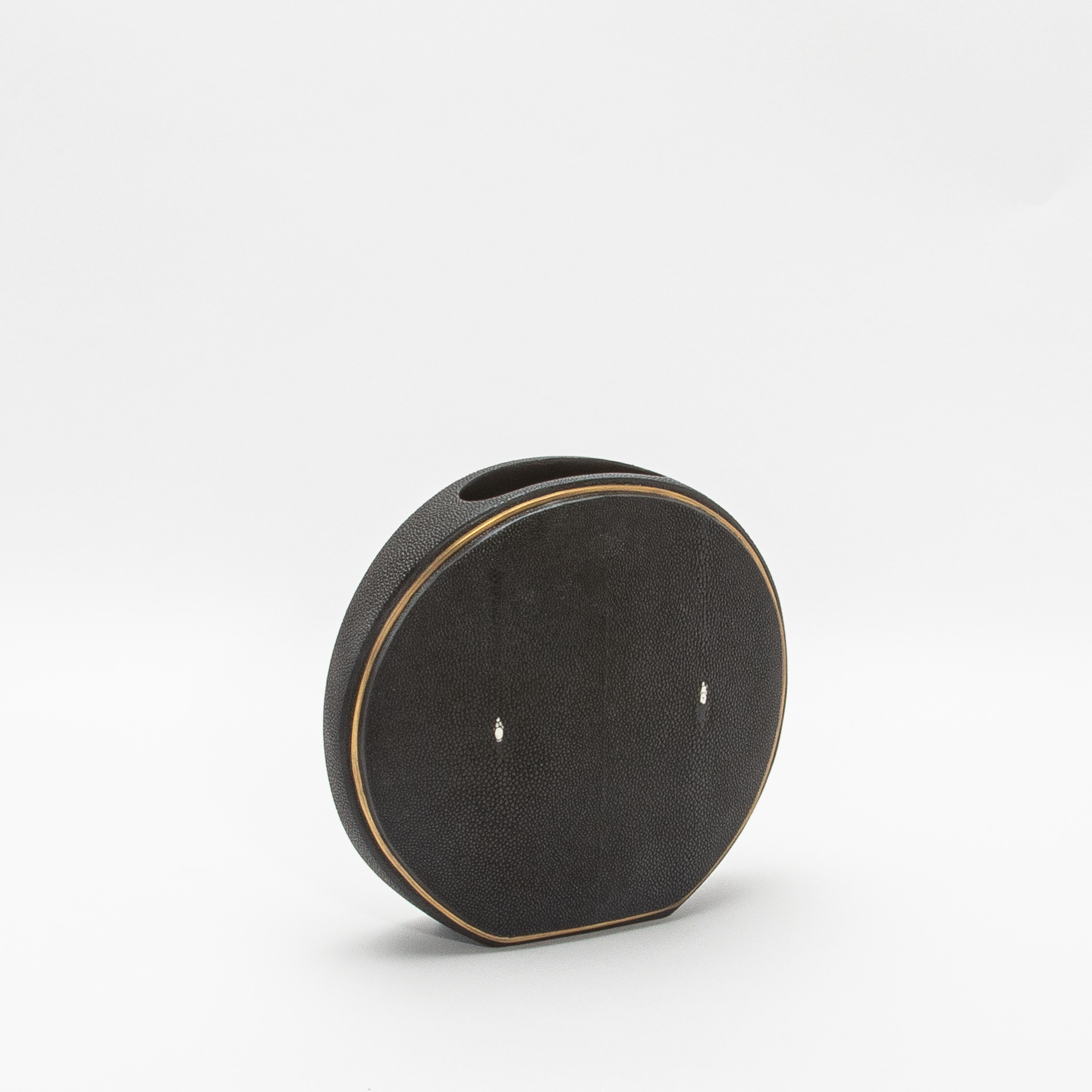 Este exquisito jarrón de R&Y Augousti captura la esencia de la artesanía con su lujosa superficie de piel de zapa, complementada con la elegancia de los detalles de latón acabados a mano. La forma redonda ofrece una silueta escultural y moderna,