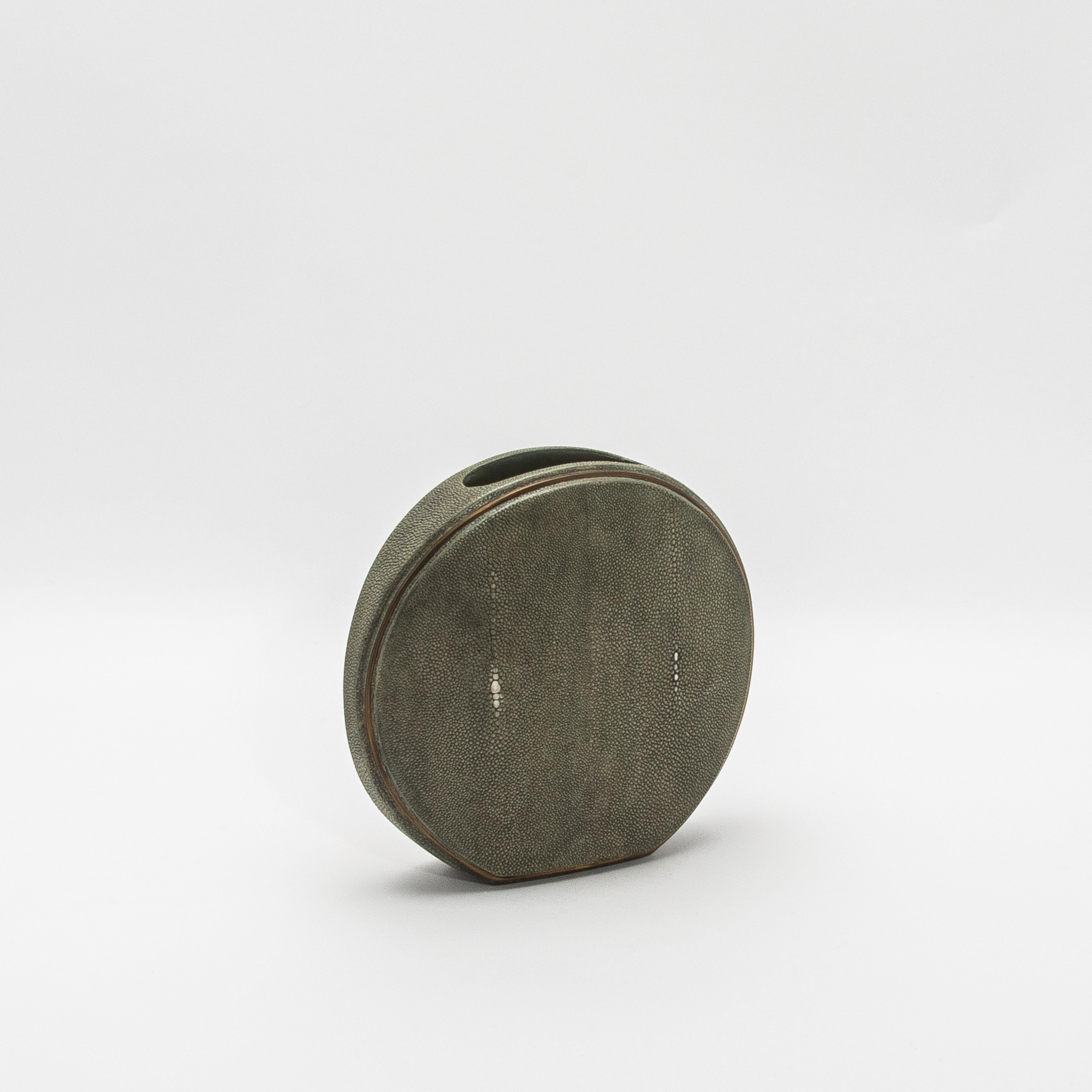Este exquisito jarrón de R&Y Augousti captura la esencia de la artesanía con su lujosa superficie de piel de zapa, complementada con la elegancia de los detalles de latón acabados a mano. La forma redonda ofrece una silueta escultural y moderna,