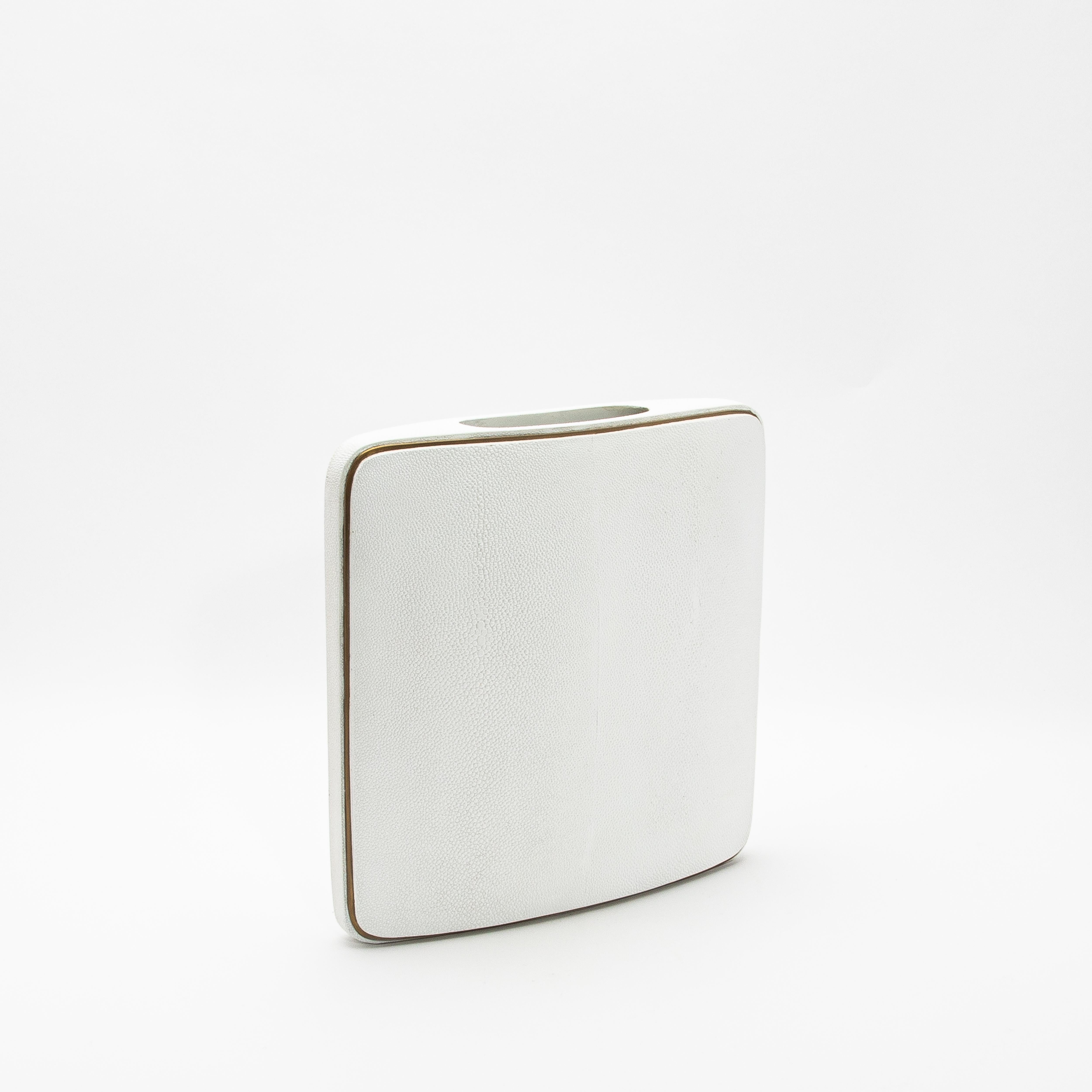 El Jarrón Shagreen de R&Y Augousti es una mezcla perfecta de materiales lujosos y artesanía refinada. Su forma cuadrada y compacta está envuelta en opulento shagreen blanco, que ofrece una textura sutil pero táctil que habla de elegancia atemporal.