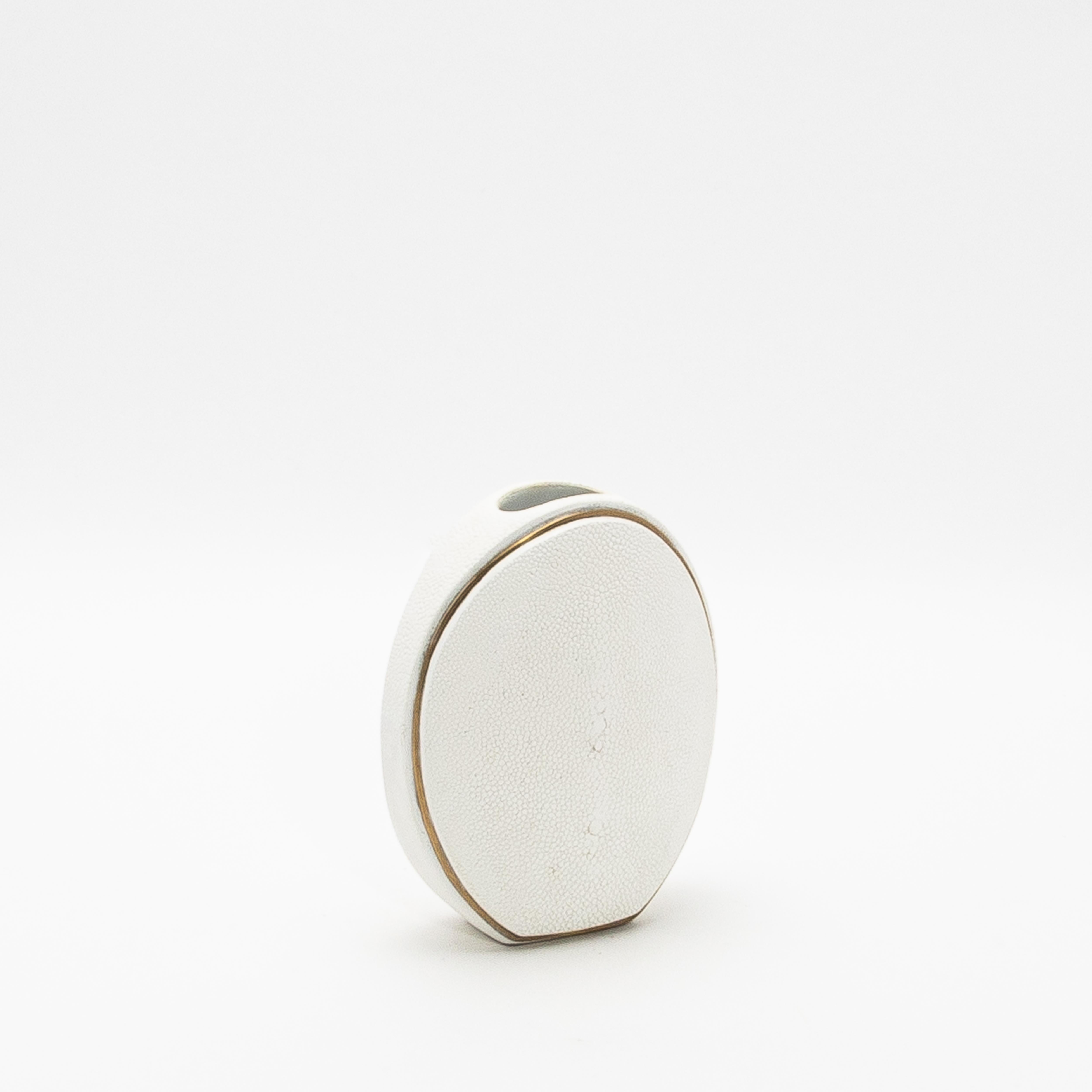 El elegante Jarrón Oval de R&Y Augousti, elaborado en piel de zapa y acentuado con latón, es una sofisticada fusión de textura orgánica y lujosos detalles. Su silueta ovalada presenta una forma llamativa, realzada por la meticulosa colocación de