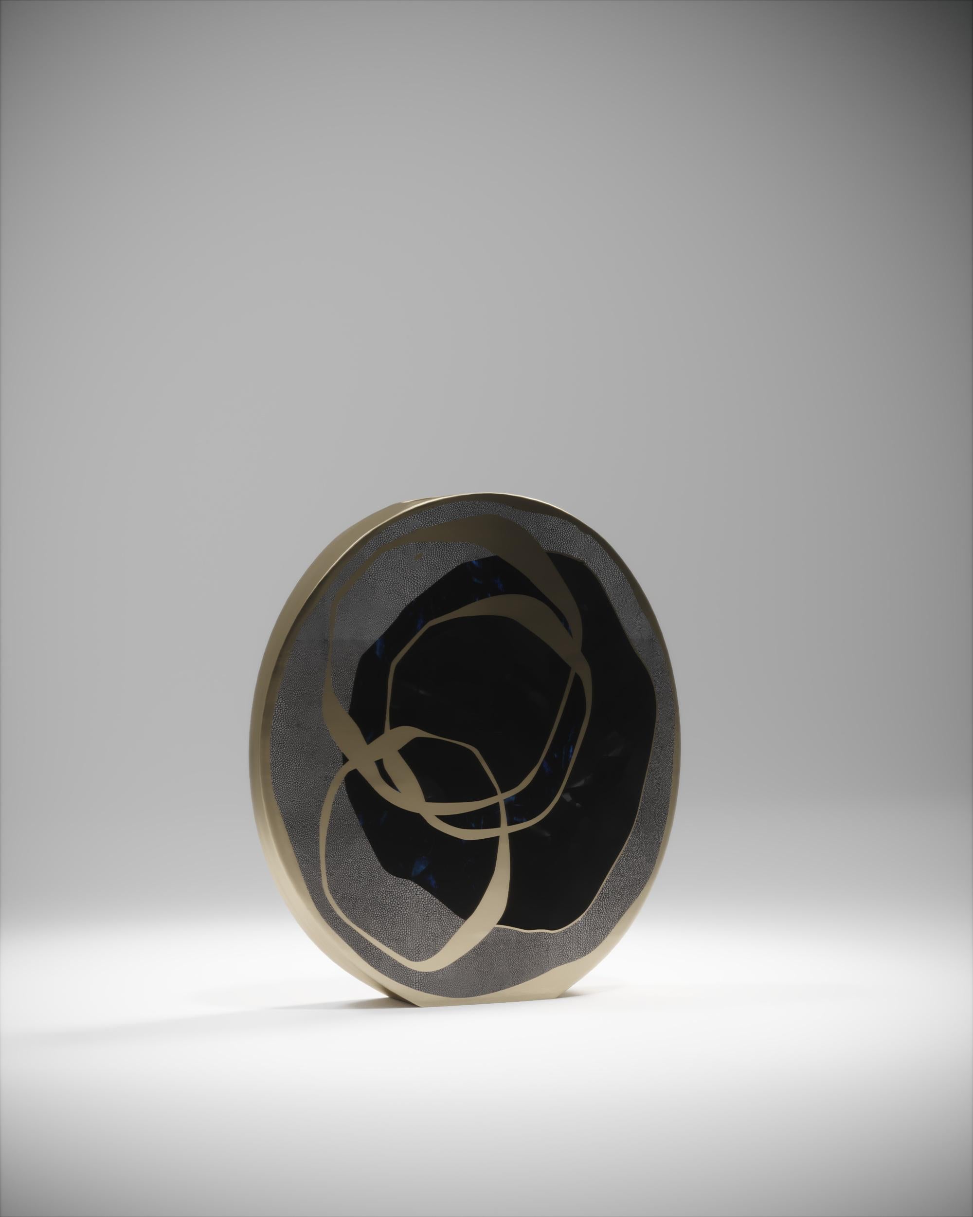 The Rose circular vase is a graphic piece that adds a statement to any space. The bold pattern is inlaid in a mixture of coal black shagreen, blue & black pen shell and bronze-patina brass. The circular vase has metal inlay on the side of the vase