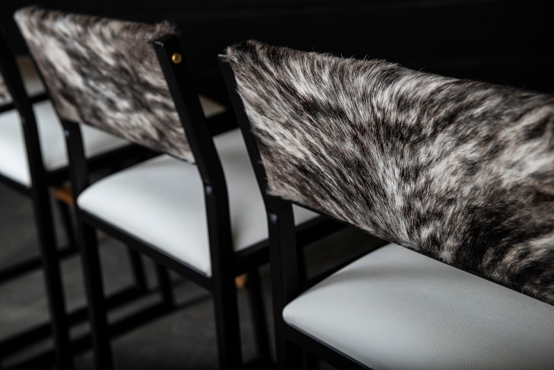 The Shaker modern bar stool chair is handmade to order from our unique Ambrozia black textured steel tubing frame and a genuine leather upholstered seat and a beautiful cowhide back. Also available in leather and COM. Inspired by the boarding ladder
