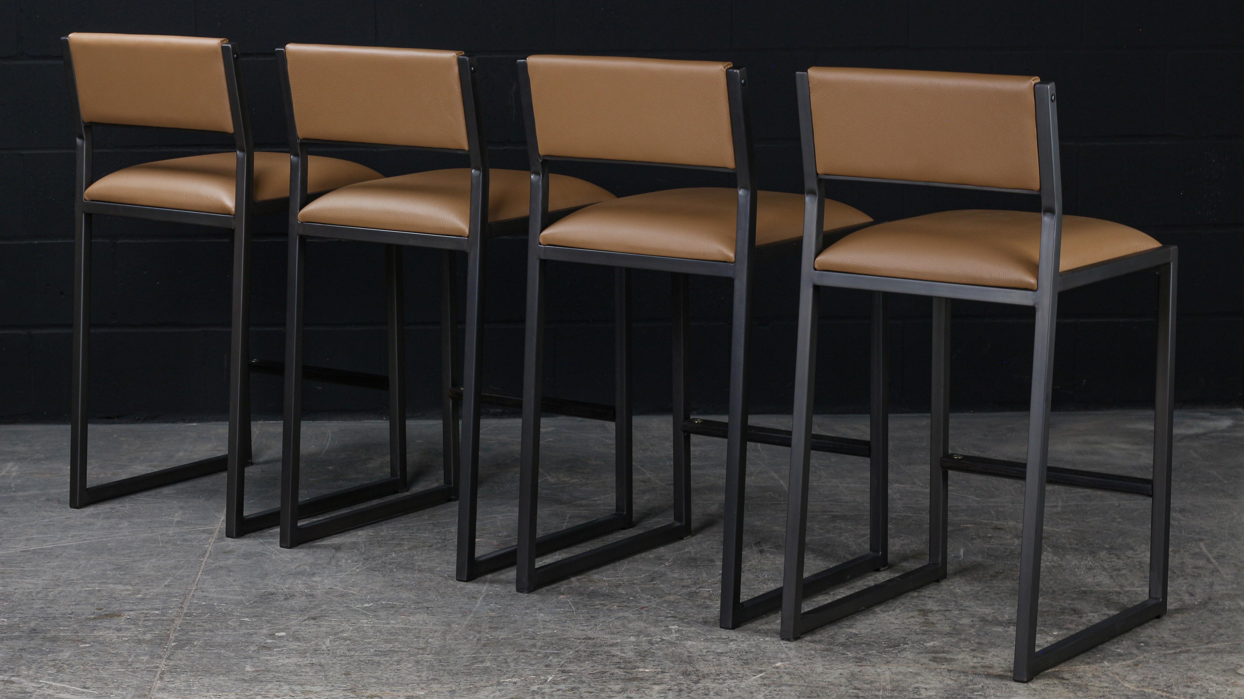 The shaker modern counter stool chair is handmade to order. Featuring our optional Luxurious Blackened steel frame and a Genuine leather seat and back. Also offered in COM or COL. Inspired by the boarding ladder steps of an old boat. The anti-slip