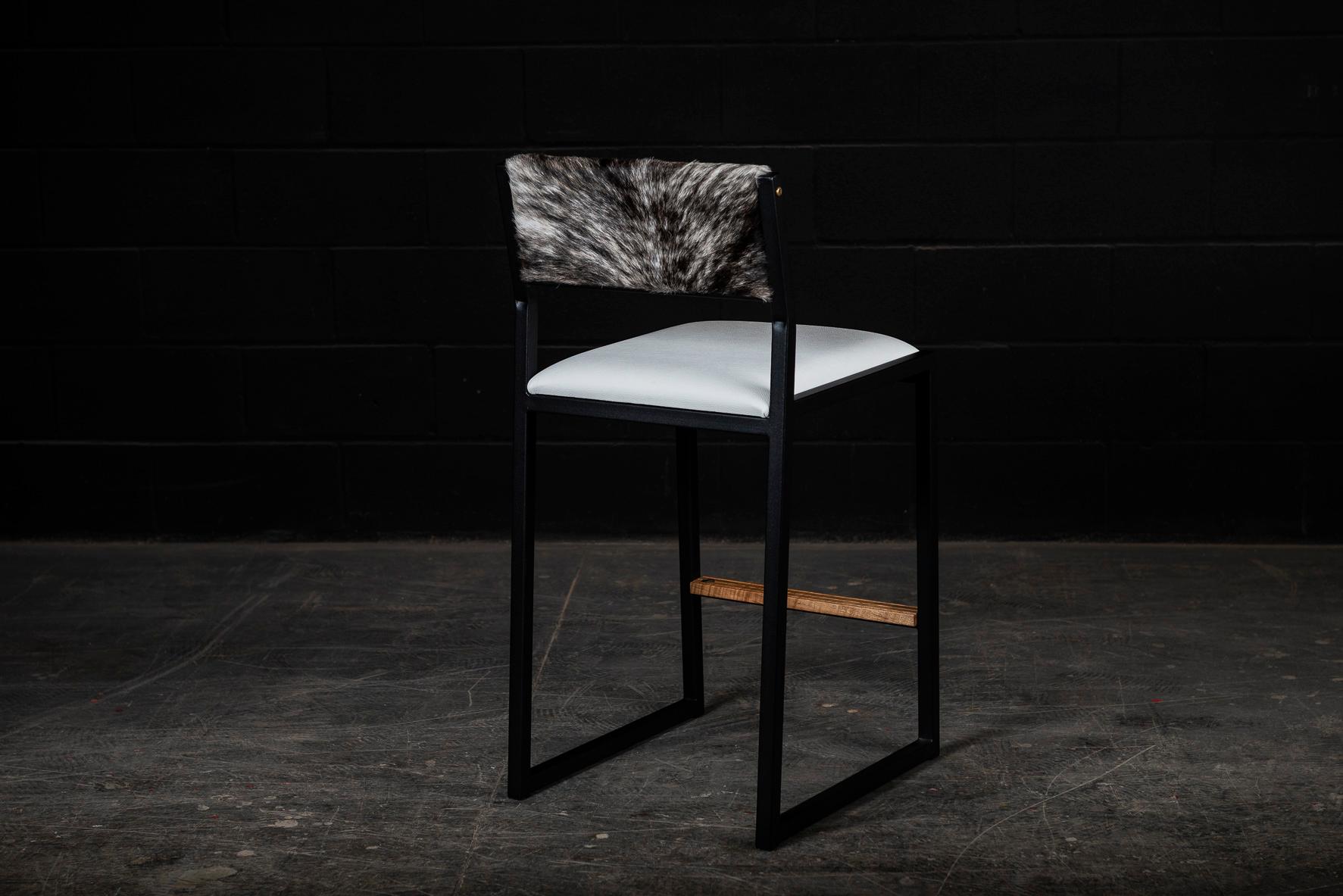 The shaker modern counter stool chair is handmade to order from our unique Ambrozia black textured steel tubing frame and a premium vinyl upholstered seat and a beautiful cowhide back. Also Available in Leather & COM. Inspired by the boarding ladder