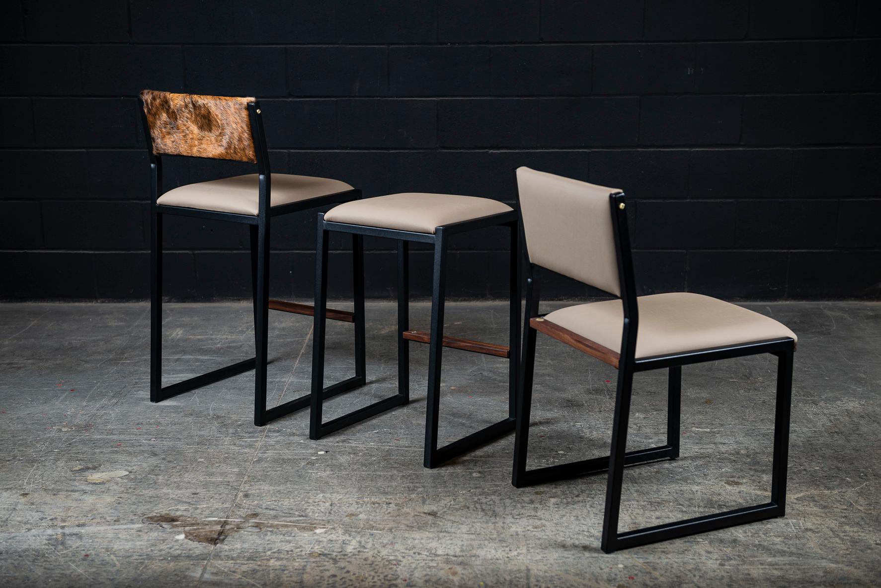 The shaker modern counter stool chair is handmade to order from our unique Ambrozia black textured steel tubing frame and a premium vinyl upholstered seat & a beautiful cowhide back. Inspired by the boarding ladder steps of an old boat. The