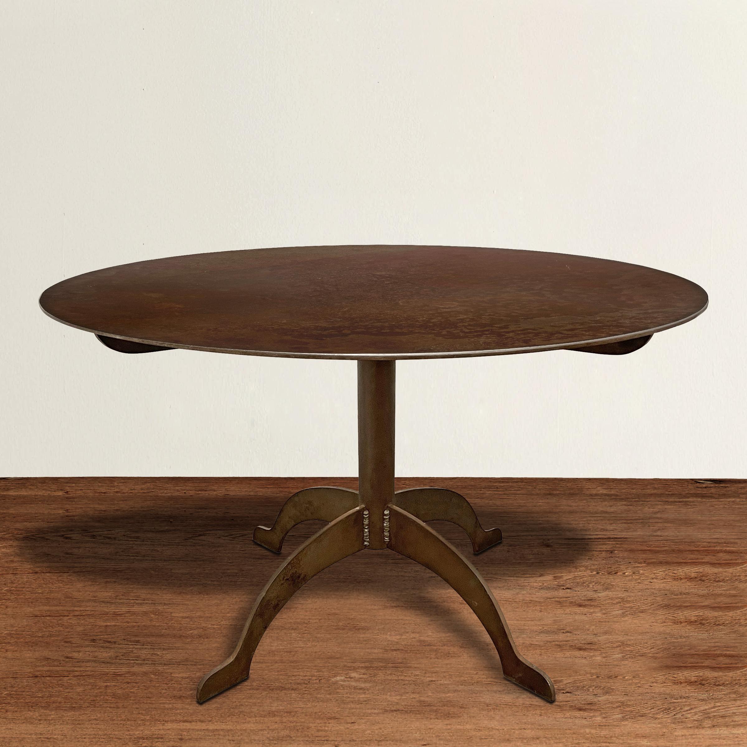 An incredible artist-made steel round dining table oozing Shaker design principles of honesty, utility, and simplicity, with four gently curved legs with pad feet in profile, and an outstanding overall naturally rusted finish. Top comes off for easy