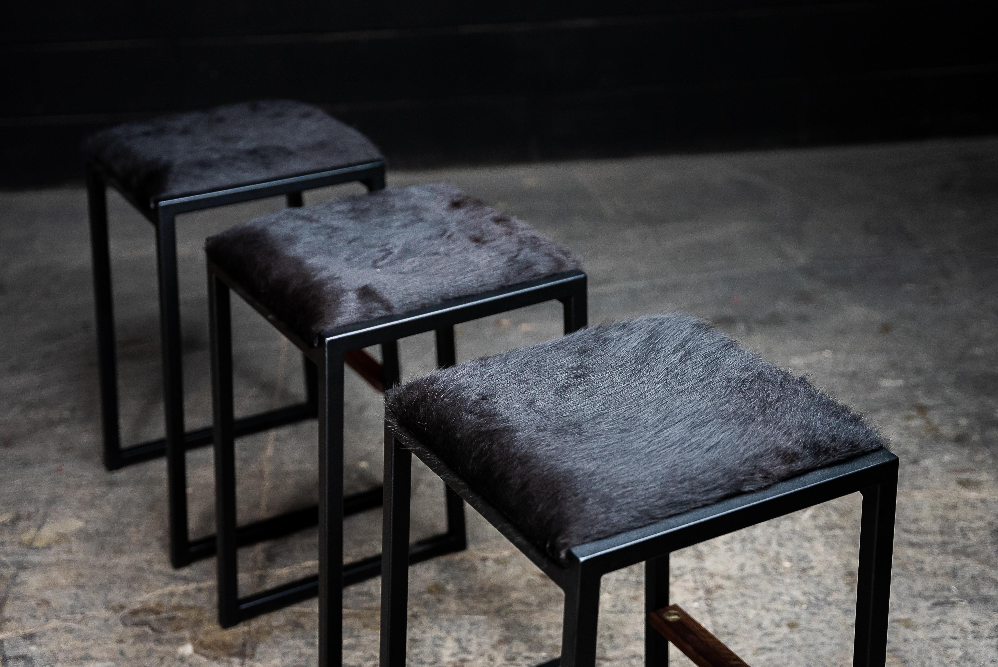 The shaker backless modern counter stool is made to order from our unique Ambrozia black textured steel tubing frame and a cowhide upholstered seat. Also available in Genuine leather. Inspired by the boarding ladder steps of an old boat. The