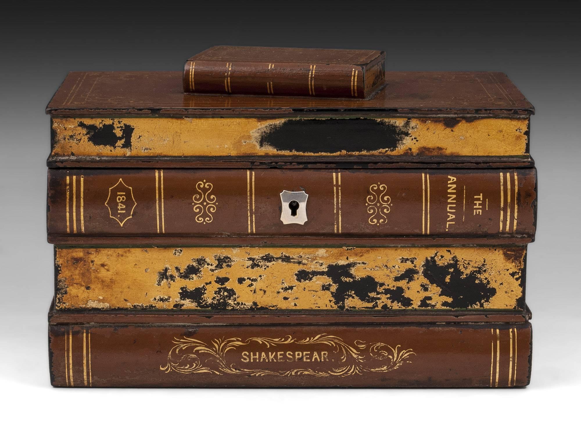 Shakespeare themed papier mache tea caddy in the form of a stack of books with ornate silvered escutcheon. This charming tea caddy is decorated in a brown finish with gold leaf decoration. 

The books spine read; The annual 1841 - Shakespeare -