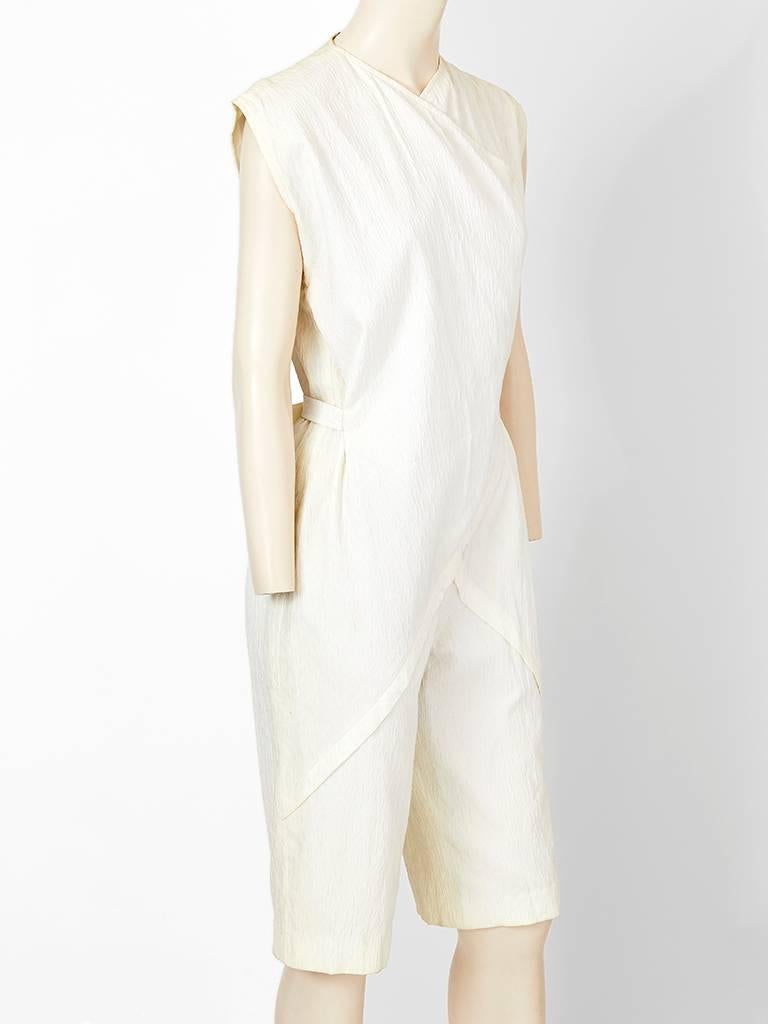Ronaldus Shamask, white cotton cloché, jumpsuit/knickers having a front, diagonal flange  detail, and an Asian inspired neckline with ties at the back waist. C. resort 1982 collection.