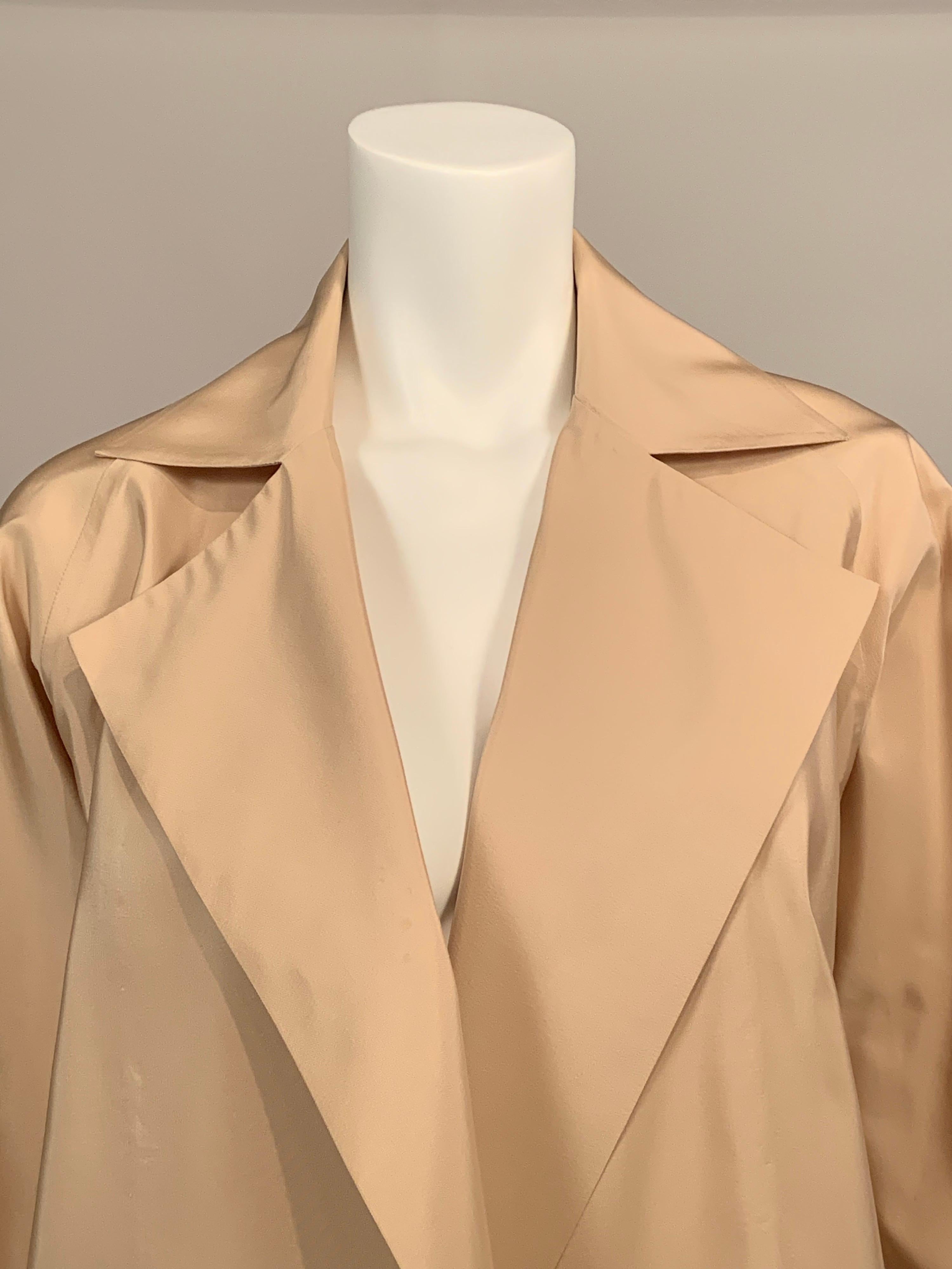 Ronaldus Shamask designs are grounded by his background in architecture.  Clean lines and straight forward design. with no unnecessary  embellishment define his style.  This spare unlined khaki colored silk coat is a wonderful example of his style. 