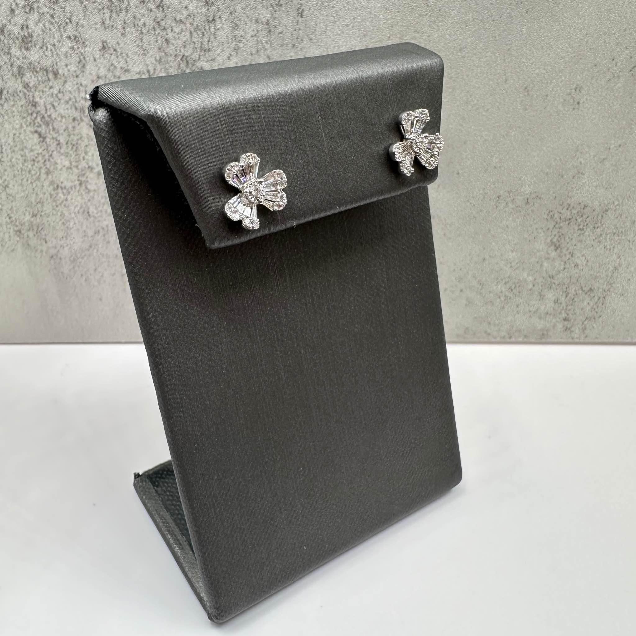 Questi eleganti orecchini Shamrock Diamond in oro bianco 18kt presentano 0,62ctw di diamanti naturali GH SI con taglio rotondo e baguette, creando un design scintillante e senza tempo. Con un peso di 2 grammi, offrono una sensazione confortevole e