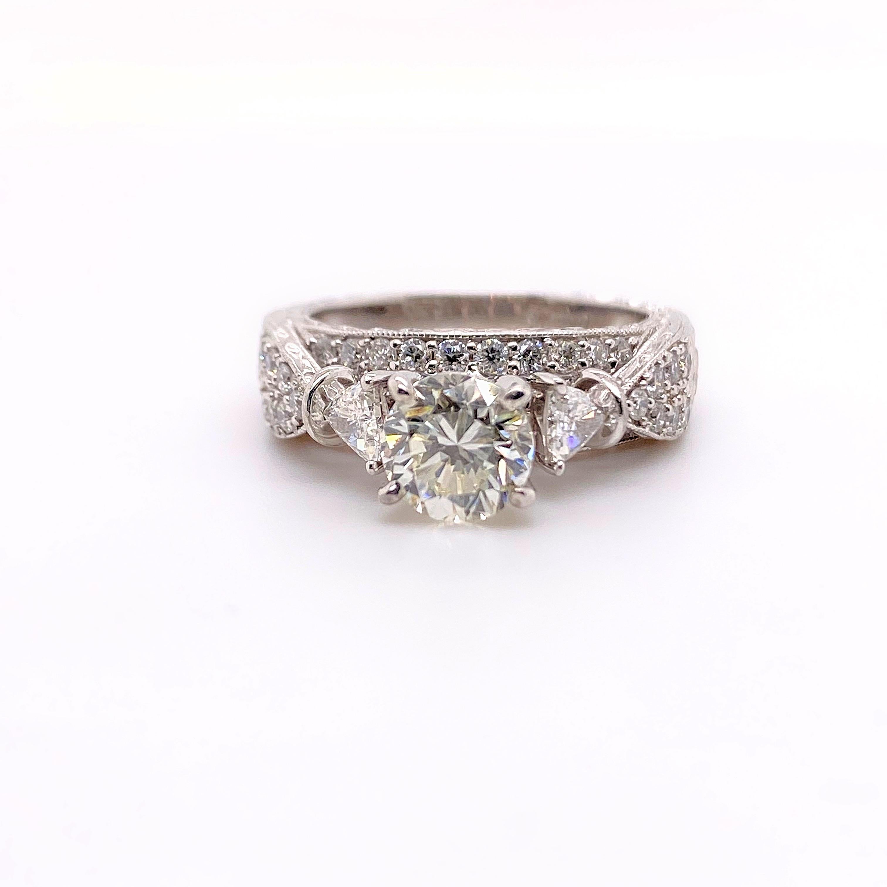 Shane Co. Diamond Ring
Style:  Delicate Floral Hand Engraved Design
Metal: 14K White Gold
Size / Measurements:  5.5, sizable
TCW:  1.75 Carats Total Approximate
Main Diamond:  1.06 Carats Round Brilliant 
Color & Clarity:  J Color,  VS1 Clarity
Side