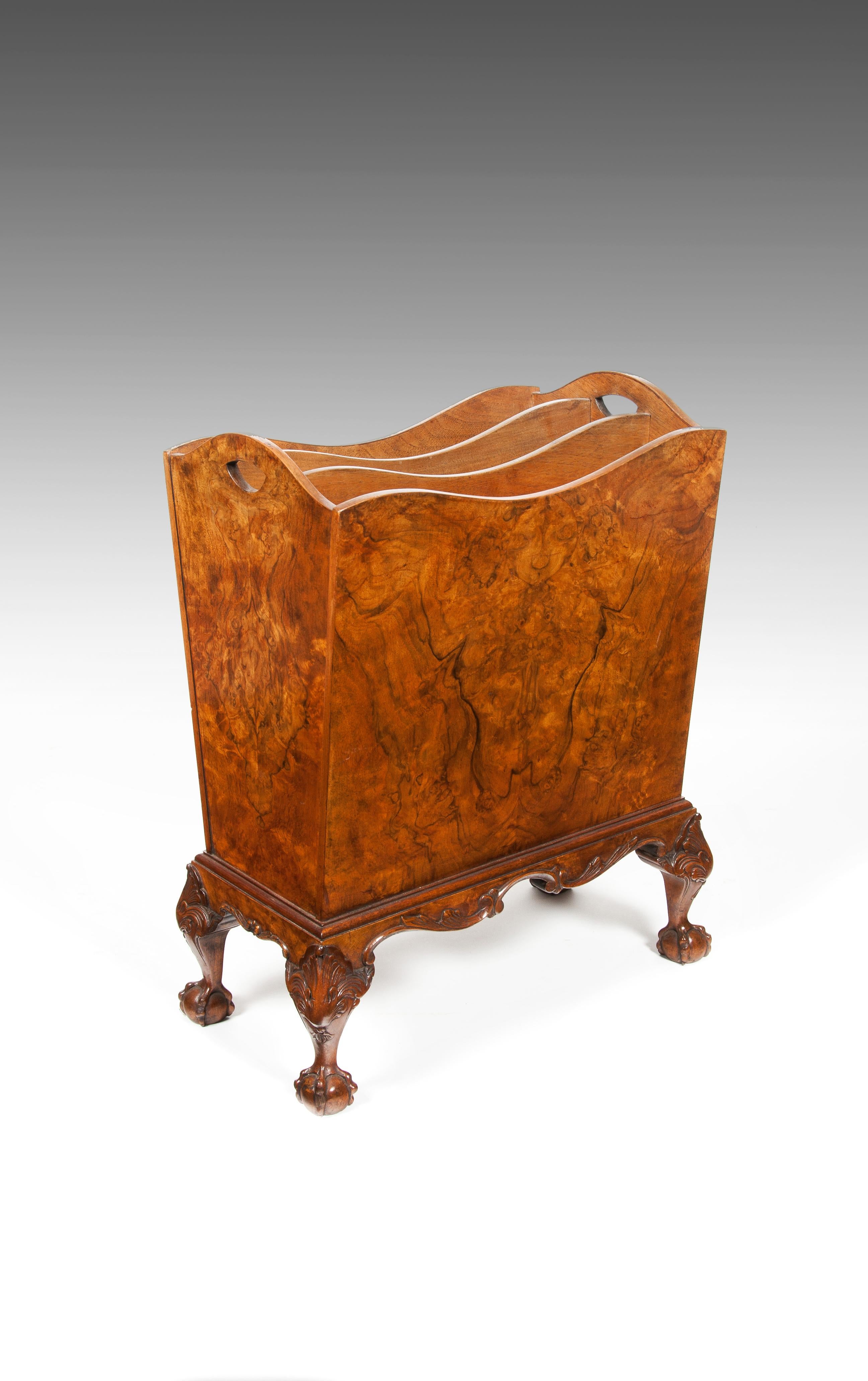 A shaped figured walnut magazine / newspaper rack on cabriole legs.

English, circa 1930s

The serpentine outlined top incorporating carrying handles, veneered in a wonderful figured walnut to all sides housing two internal dividers, raised on a
