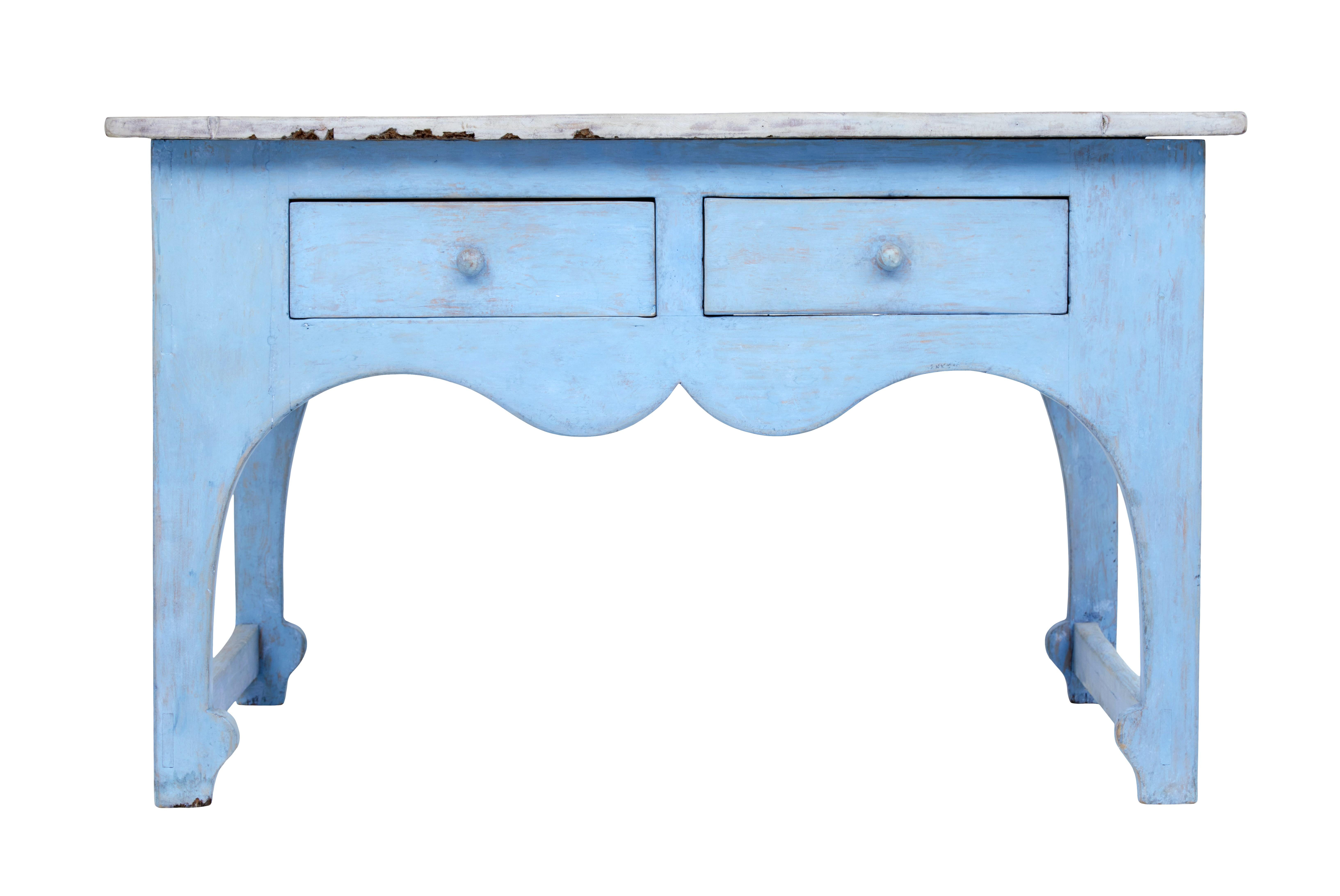 Shaped mid 19th century painted Swedish pine side table circa 1860.

Unusually shaped rustic Swedish table with shaped front freize. Grey washed over sailing top surface, standing on a blue painted base. 2 drawers to the front for storage. Shaped