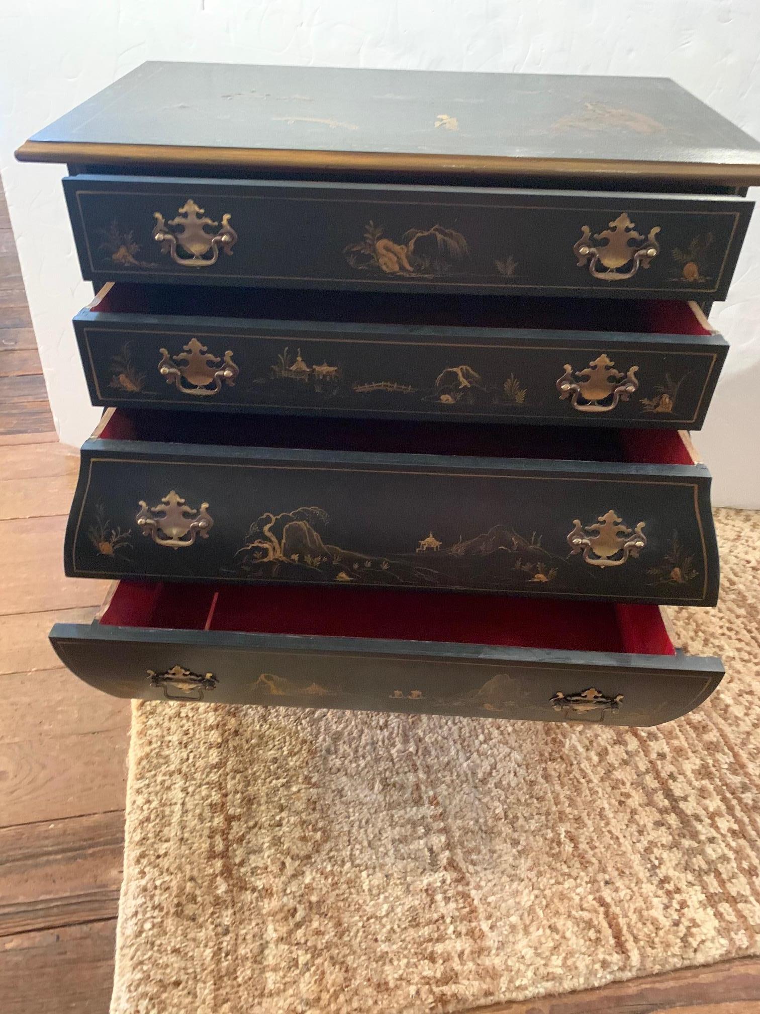 Wonderfully shaped black and gold chinoiserie vintage chest of drawers having 4 drawers, bulbous bottom, cabriole legs with ball and claw feet, and chippendale style brass hardware. Painted decoration is lovely and includes figures, pagodas, birds