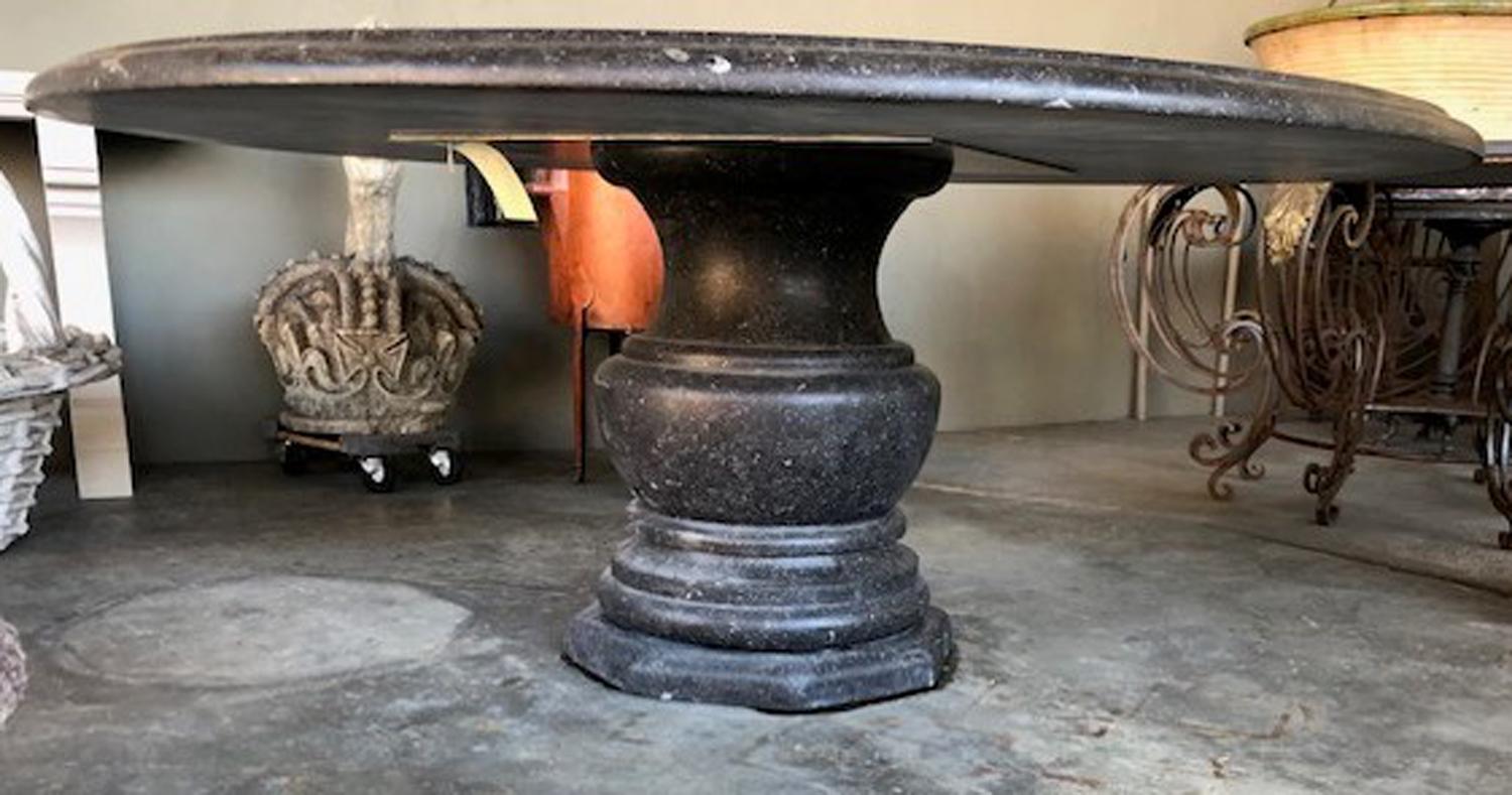 Made from Belgian bluestone with a honed finish and embedded with fossils, the table is comprised of a thick round top with dupont edge and baluster-form support on an octagonal plinth. New with only minimal wear expected; table is ideal for