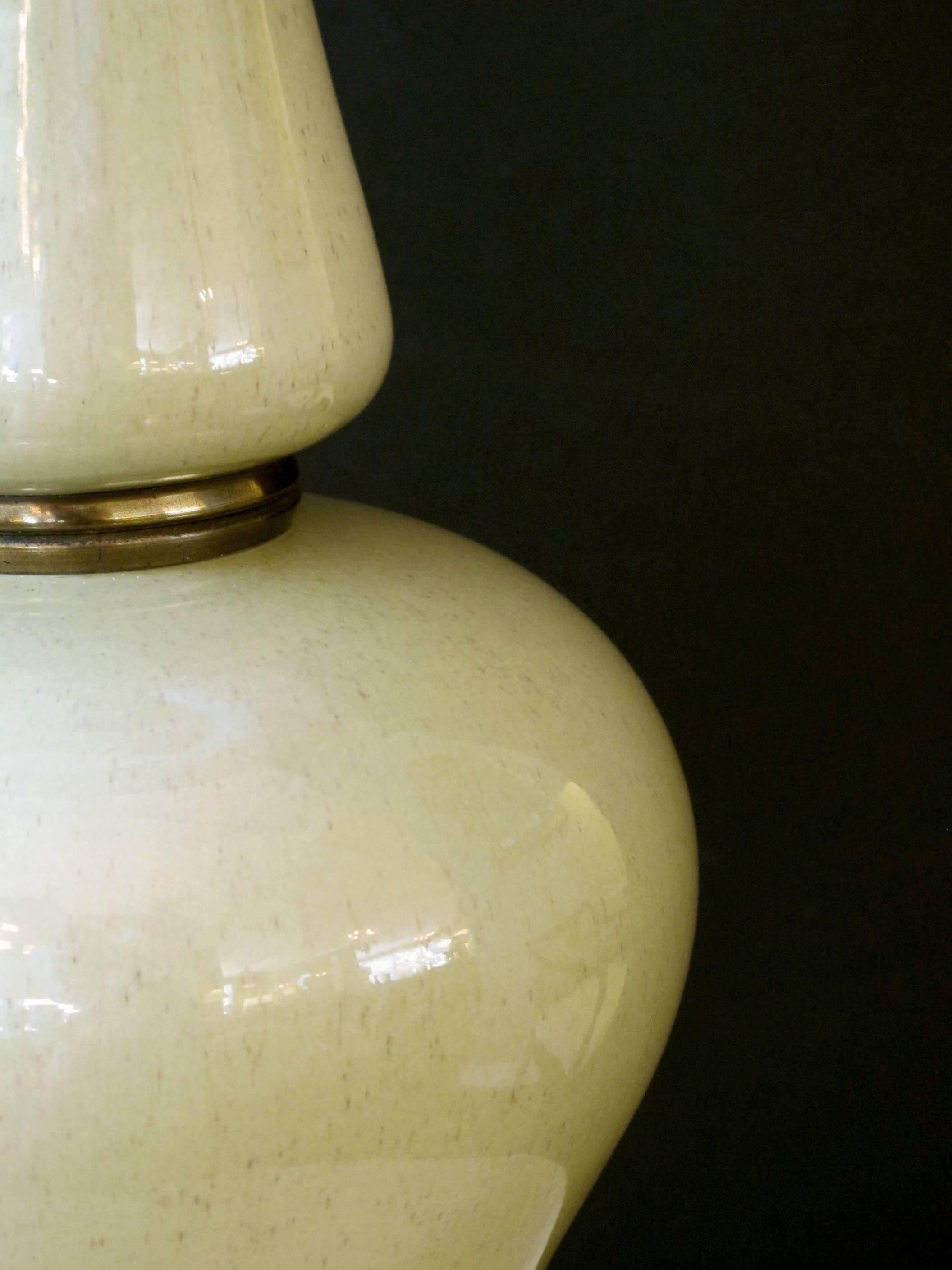 A shapely pair of American midcentury celadon green baluster-form ceramic lamps; by Frederick Cooper, Chicago; each with long neck above a bulbous body flaring at the base.