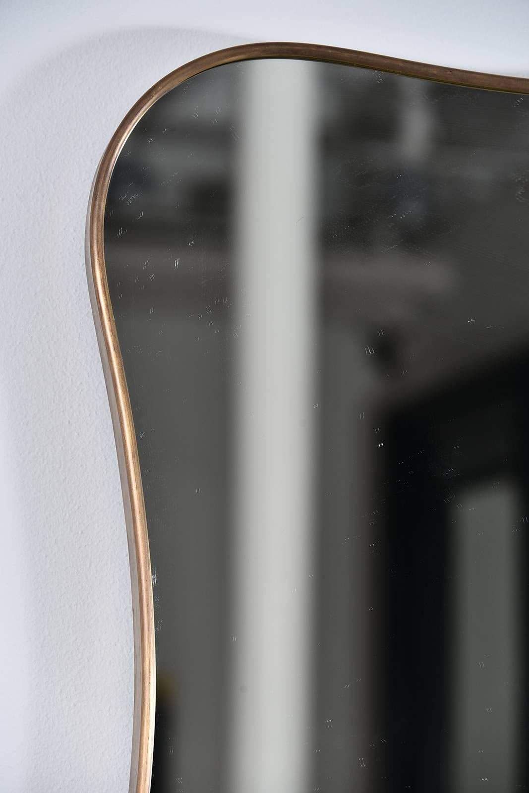 Beautiful curvy, 1950s thin frame brass mirror.