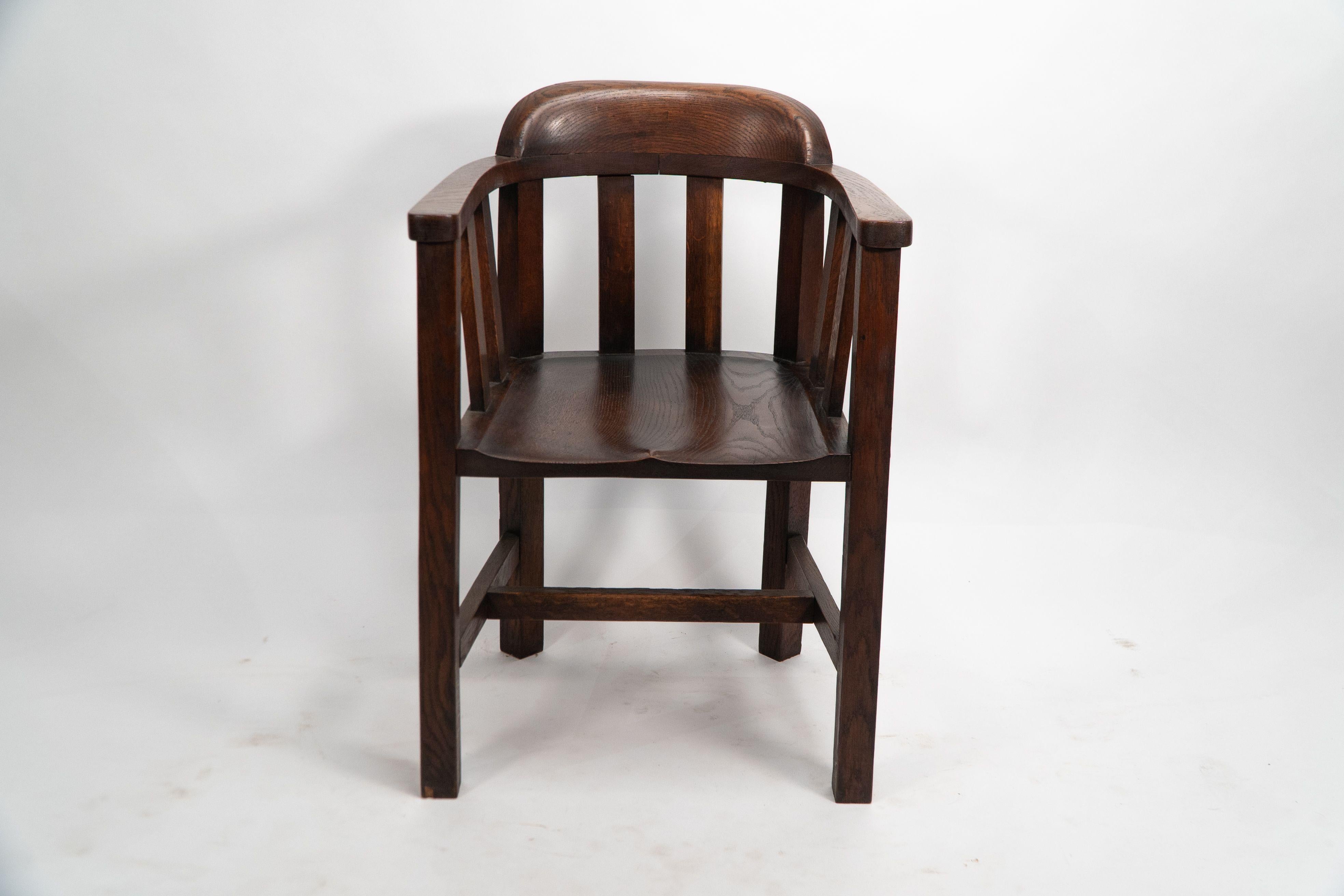 Shapland und Petter. Eine lange Reihe von Wannenstühlen aus Eichenholz im Arts-and-Crafts-Stil mit geformtem massivem Sitz und geformter Kopfstütze. Ein interessantes Detail an den hinteren Beinen, die in einem Winkel von 45 Grad zu den vorderen