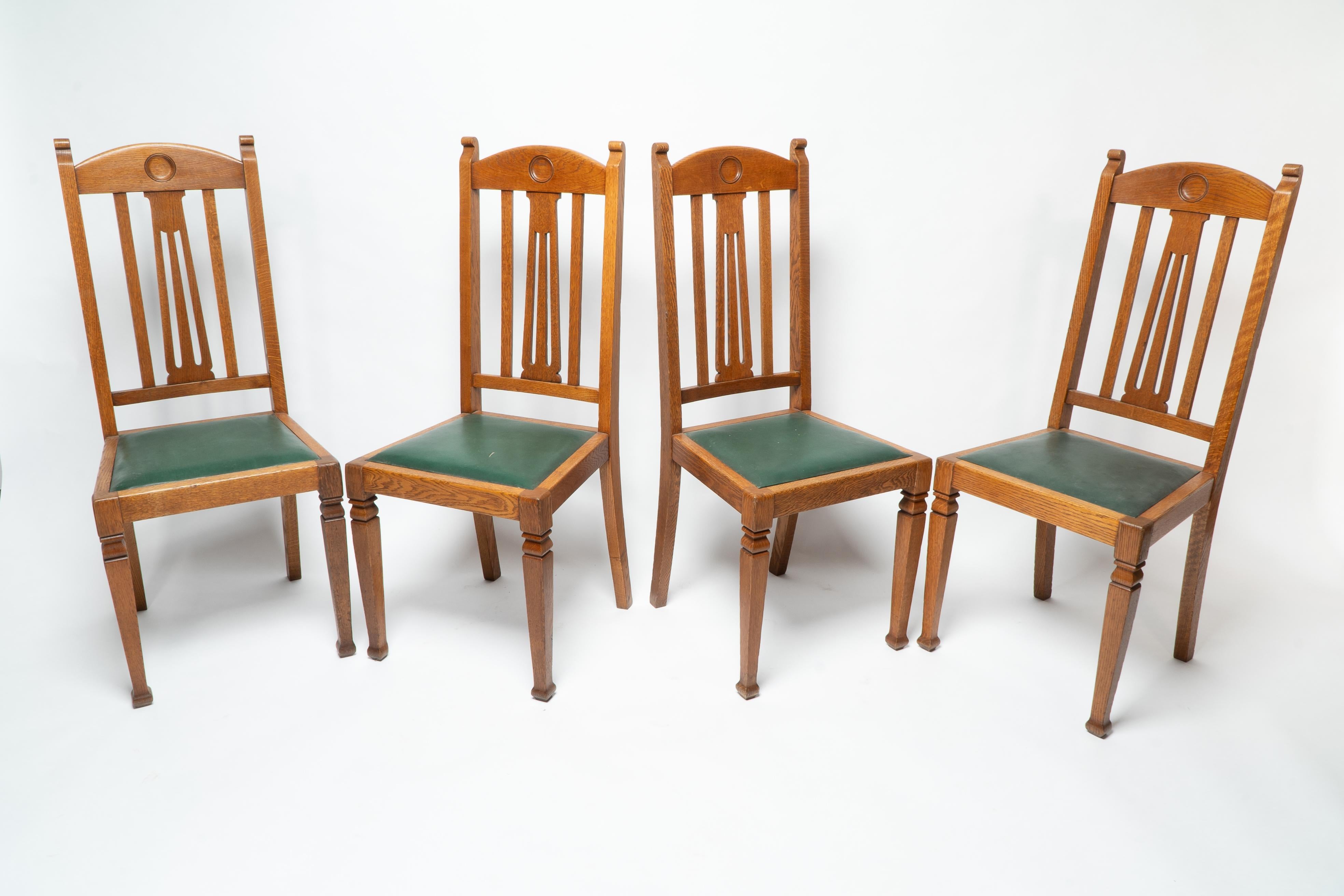 Shapland et Petter. Un ensemble de quatre chaises de salle à manger en chêne de style Arts and Crafts avec des sièges en cuir