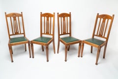 Shapland and Petter. A set of four Arts and Crafts oak dining chairs