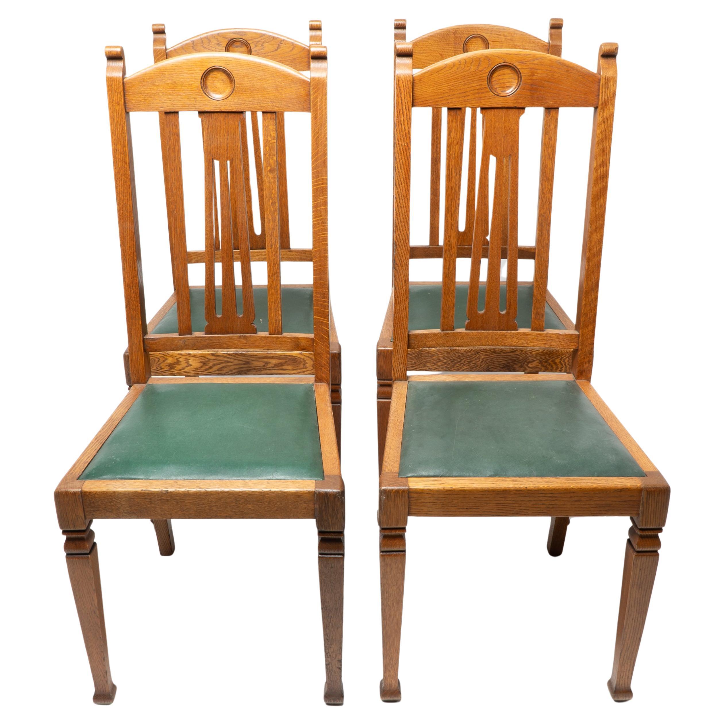 Shapland and Petter. A set of four Arts and Crafts oak dining chairs