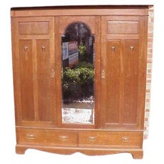 Shapland and Petter. An Arts and Crafts oak treble wardrobe and Dressing table
