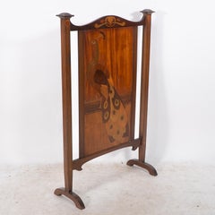 Shapland and Petter. An Arts & Crafts firescreen with a beautiful peacock inlaid