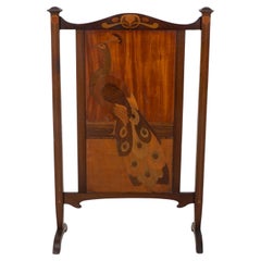 Shapland & Petter. Una pantalla de chimenea Arts & Crafts con un hermoso pavo real incrustado