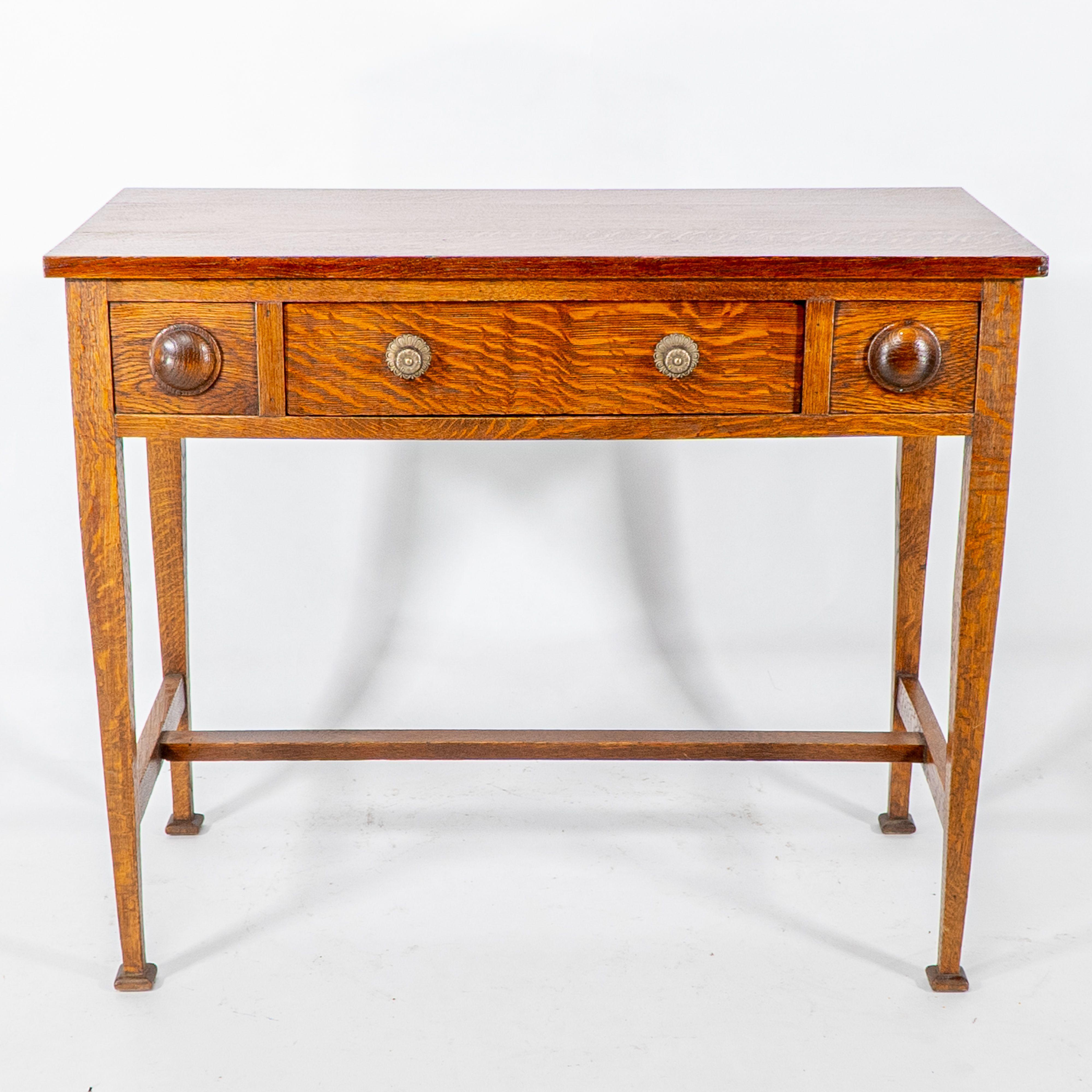 Shapland und Petter. Ein Arts and Crafts Tisch oder kleiner Schreibtisch aus Eiche mit zentraler Schublade, flankiert von dekorativen Rondellen. Boden bis zur Unterkante des Tisches: 59 cm
