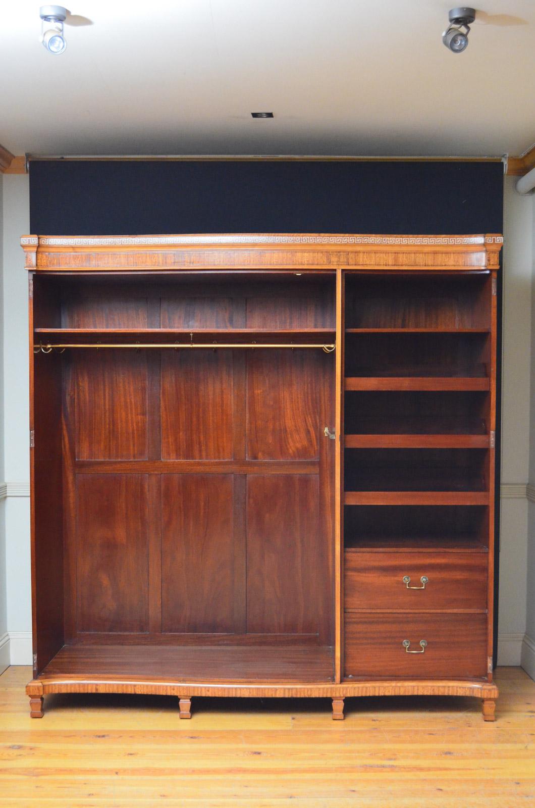 Sn4414, fine quality Edwardian Shepland and Petter satinwood wardrobe of serpentine design, having string inlaid frieze above 3 finely inlaid doors enclosing double hanging section, sliders and drawers, all fitted with original brass handles and