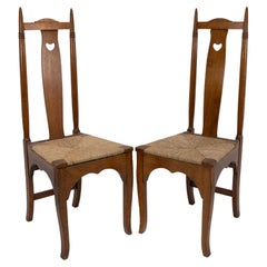 Shapland & Petter, Paar Arts & Crafts-Esszimmerstühle aus Eichenholz mit durchbrochenen Herzen