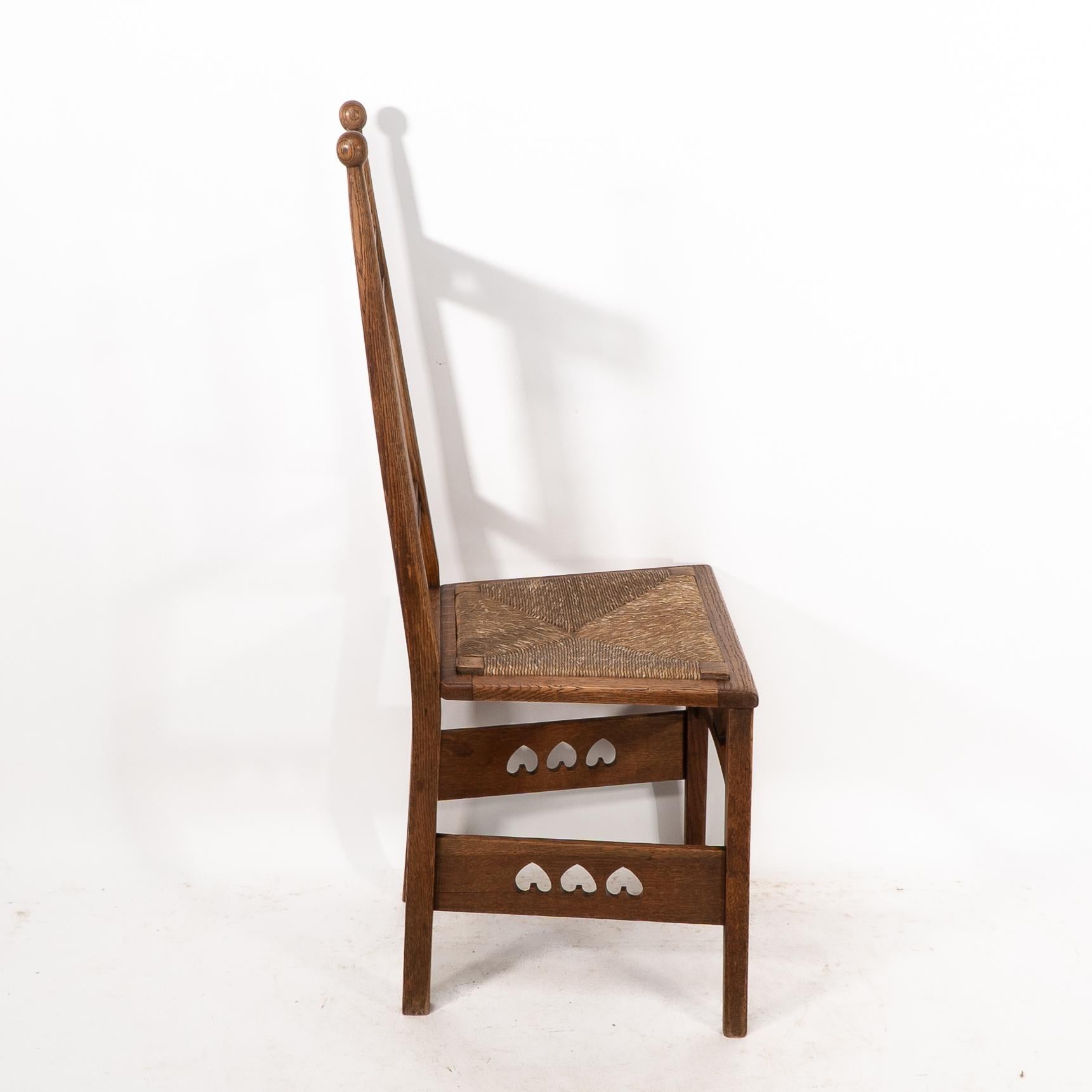 Arts and Crafts Shapland & Petter. An Arts & Crafts oak desk or side chair with pierced hearts For Sale