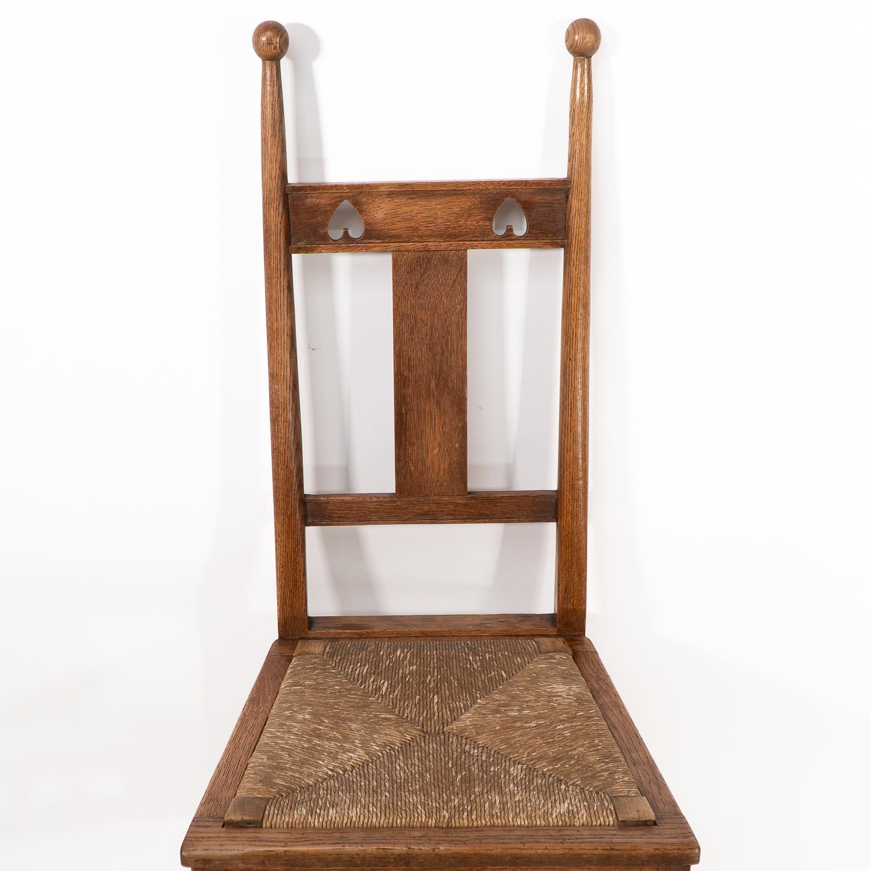 Early 20th Century Shapland & Petter. An Arts & Crafts oak desk or side chair with pierced hearts For Sale