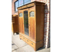 Gillows. An Arts & Crafts Oak Treble Wardrobe with Ebony Floral Inlays